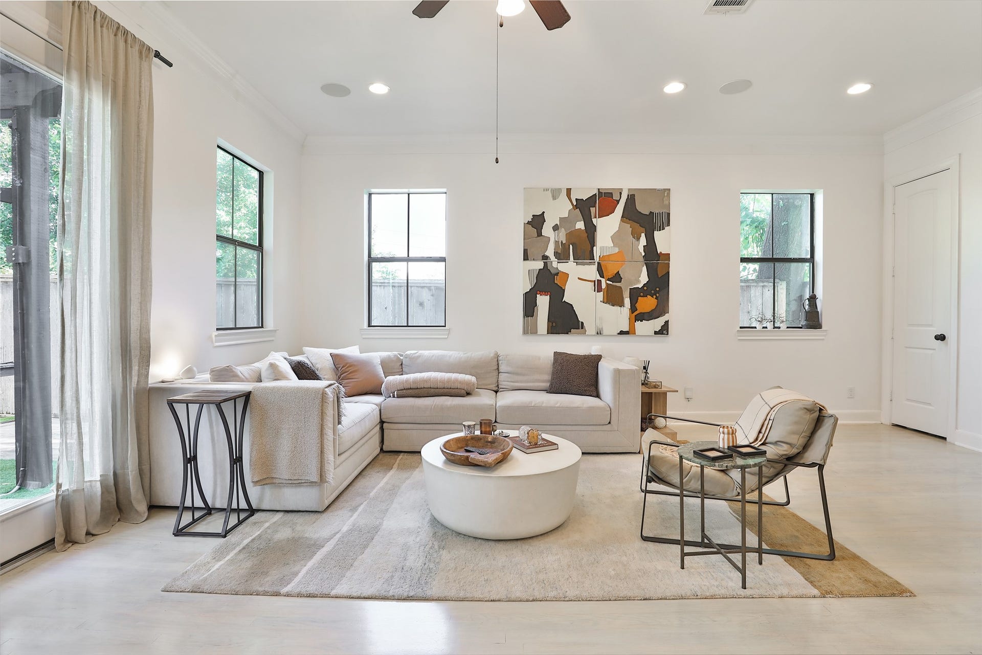 1112 Bingham Street, Houston, TX 77007 Bright and inviting living room with modern decor, featuring a cozy sectional sofa, abstract artwork, and large windows that fill the space with natural light.