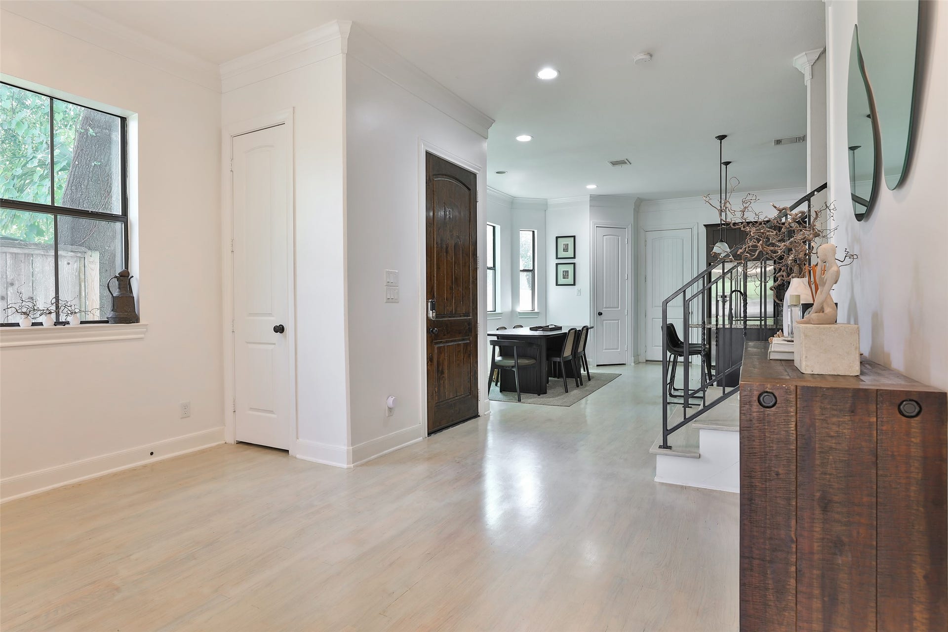 1112 Bingham Street, Houston, TX 77007 Bright and inviting entryway featuring light wood flooring, a stylish staircase, and a view into the dining area with ample natural light.
