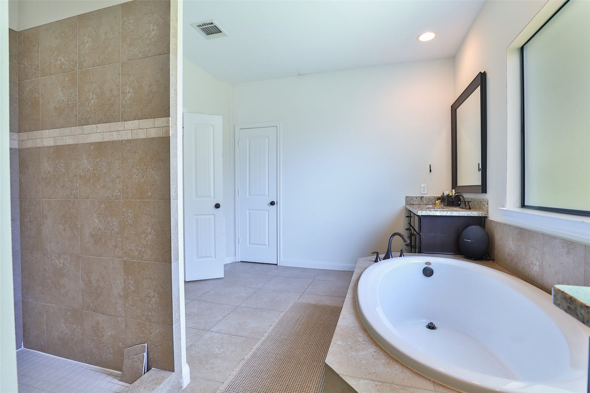 1112 Bingham Street, Houston, TX 77007 Spacious bathroom featuring a luxurious soaking tub, elegant vanity, and a large tiled shower for a relaxing retreat.