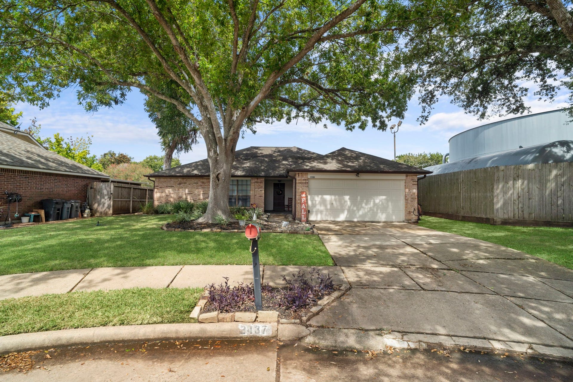 2437 Willow Bend Drive, Richmond, TX 77406 Single-story home with a spacious driveway and lush front yard, shaded by a large, mature tree sits at the end of the cup-de-sac