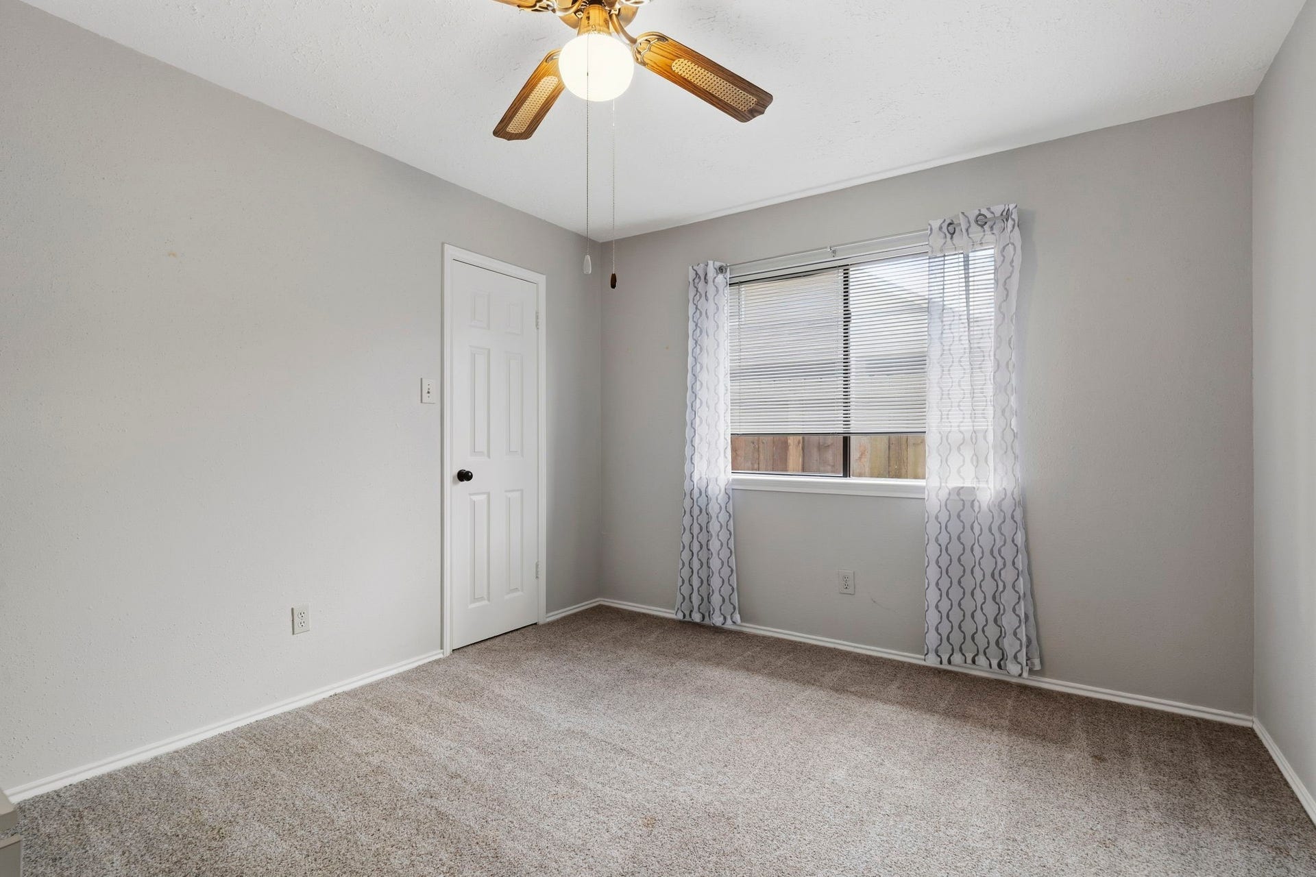 2437 Willow Bend Drive, Richmond, TX 77406 Cozy bedroom featuring neutral walls, plush carpeting, walk-in closet, and a ceiling fan offers natural light streaming through a window adorned with elegant curtains.