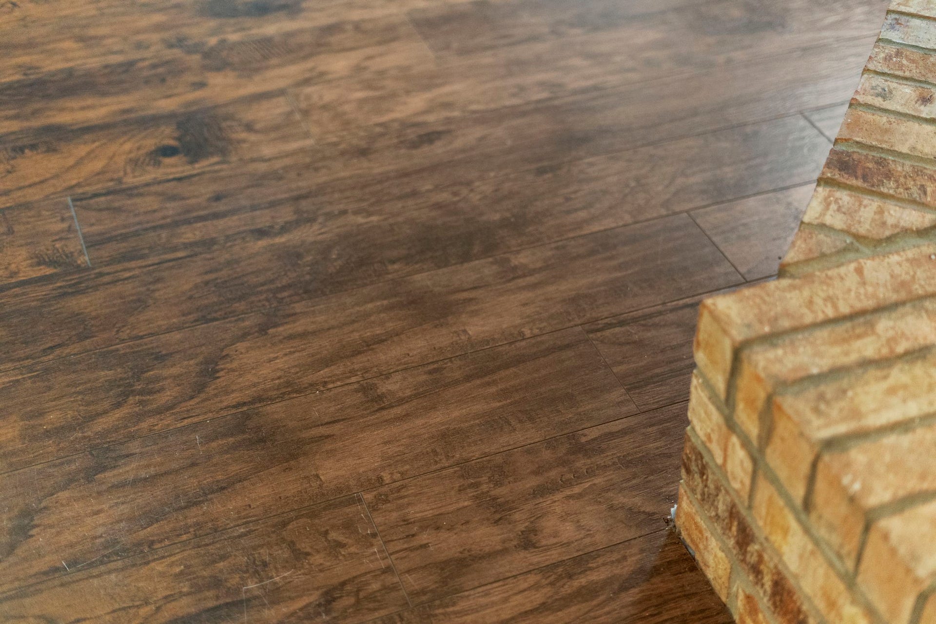2437 Willow Bend Drive, Richmond, TX 77406 The elegant laminate wood flooring complements the rustic charm of the brick fireplace, creating a warm and inviting atmosphere.