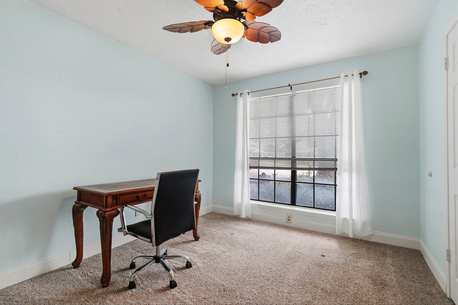2437 Willow Bend Drive, Richmond, TX 77406 Bright and inviting secondary bedroom with a soft color walls, featuring a large window for natural light, elegant ceiling fan, and plush carpeting.