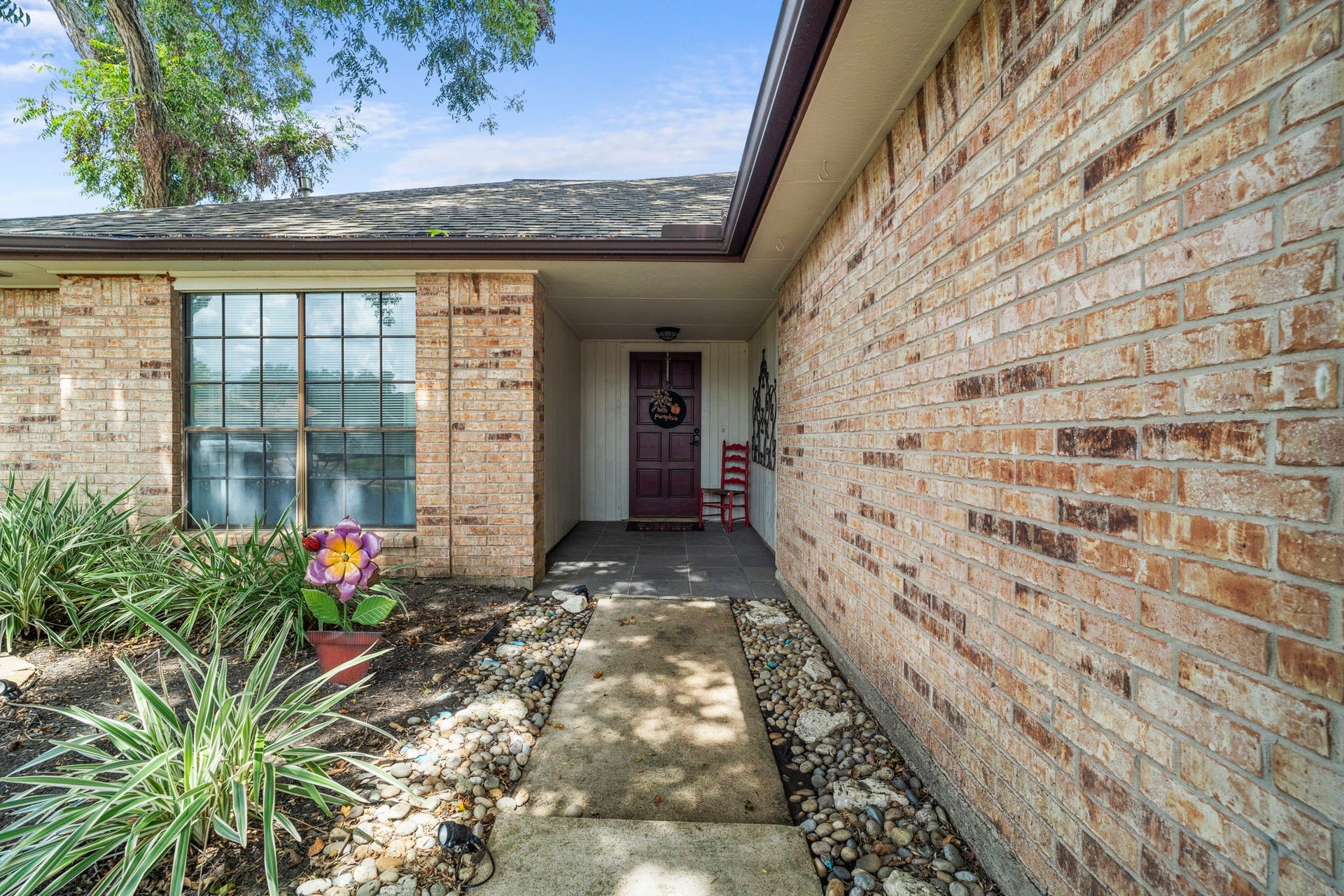 2437 Willow Bend Drive, Richmond, TX 77406 Brick exterior with a welcoming front porch, accented by lush greenery and a vibrant garden.