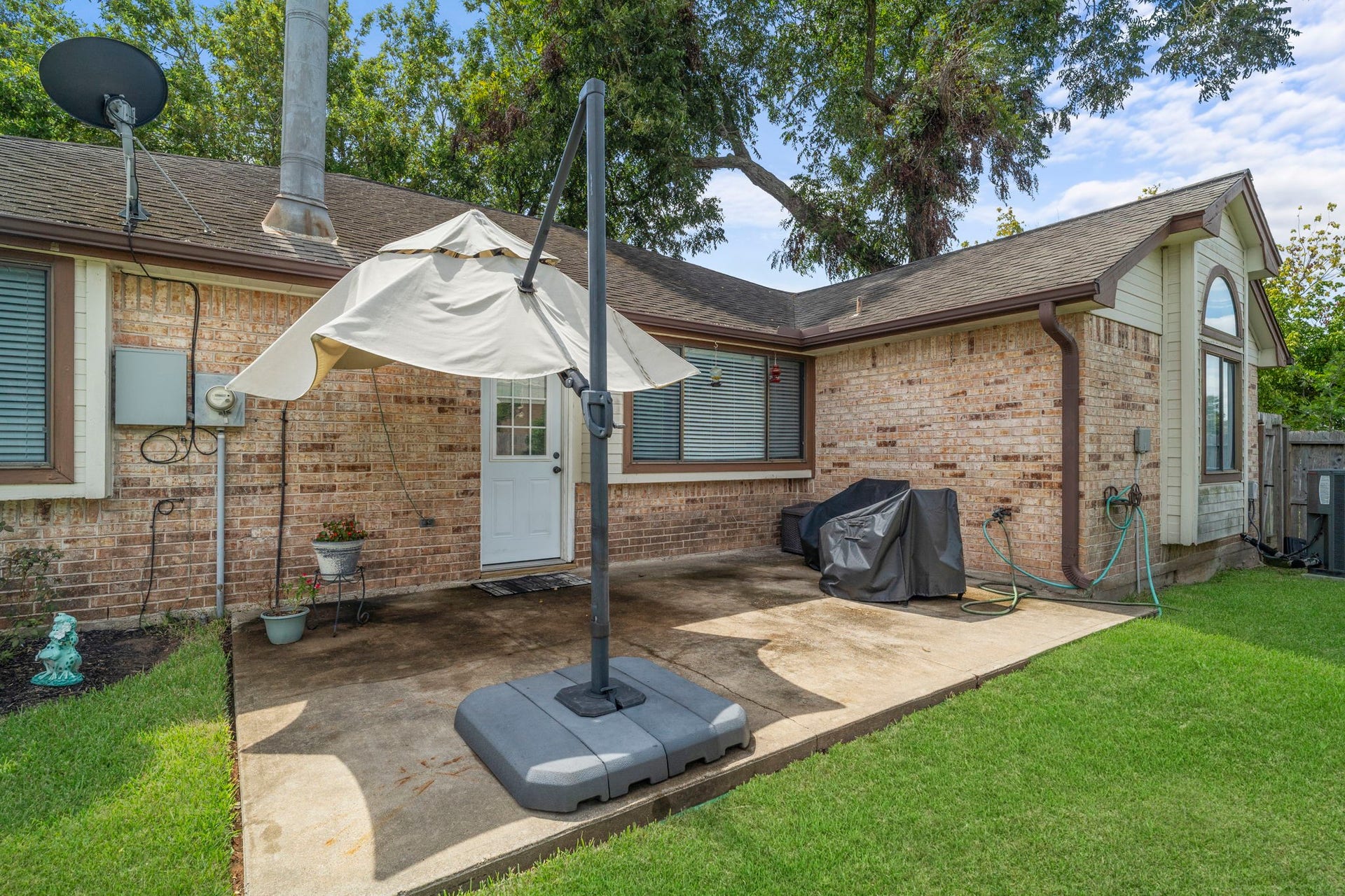 2437 Willow Bend Drive, Richmond, TX 77406 Backyard patio is perfect for outdoor relaxation. A well-maintained brick exterior and lush green lawn enhance the inviting atmosphere.