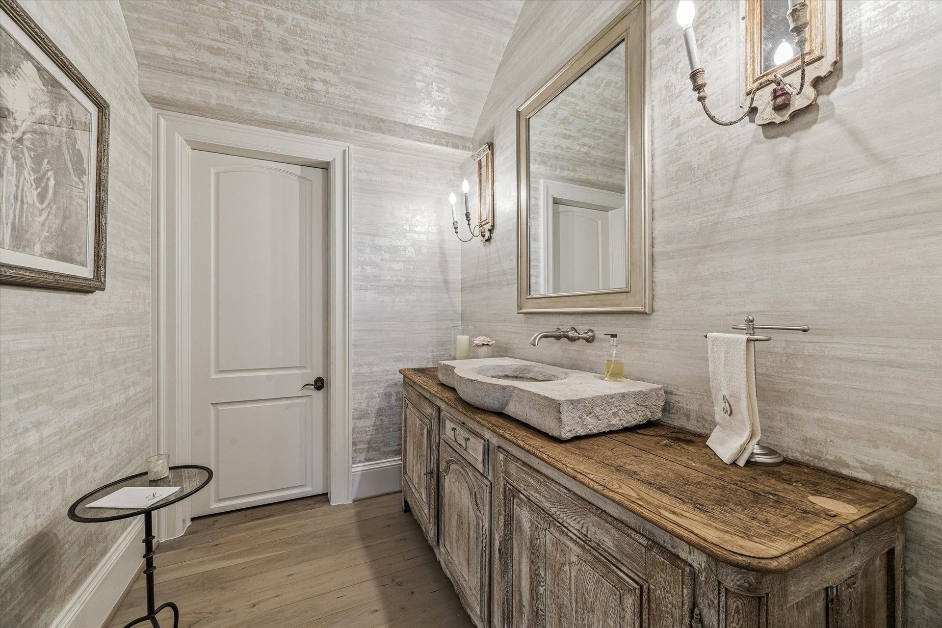 Gorgeous powder bath on the first floor featuring antique cabinetry with wood top, stone sink from Chateau Domingue, and Segreto plastered walls.