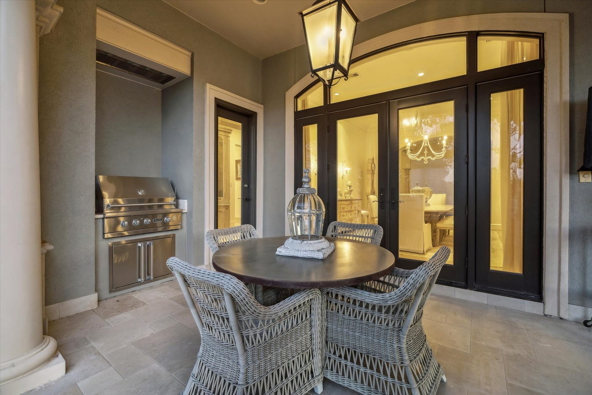 Covered back patio with built-in grill, outdoor dining area, and direct access to the interior living spaces.