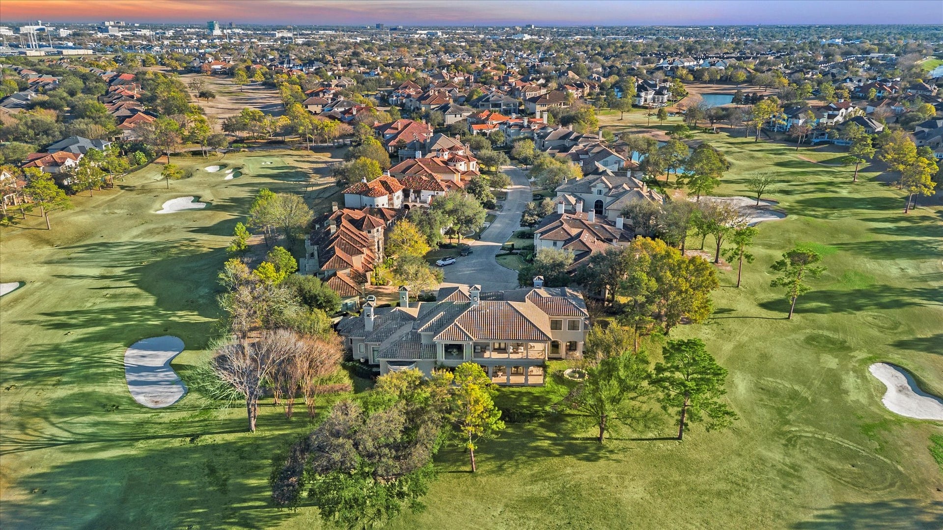 Aerial view showcasing the homes premier golf course setting within a well-established community, with expansive fairway and neighborhood views. This home is located in the Estates of Royal Oaks Country Club.