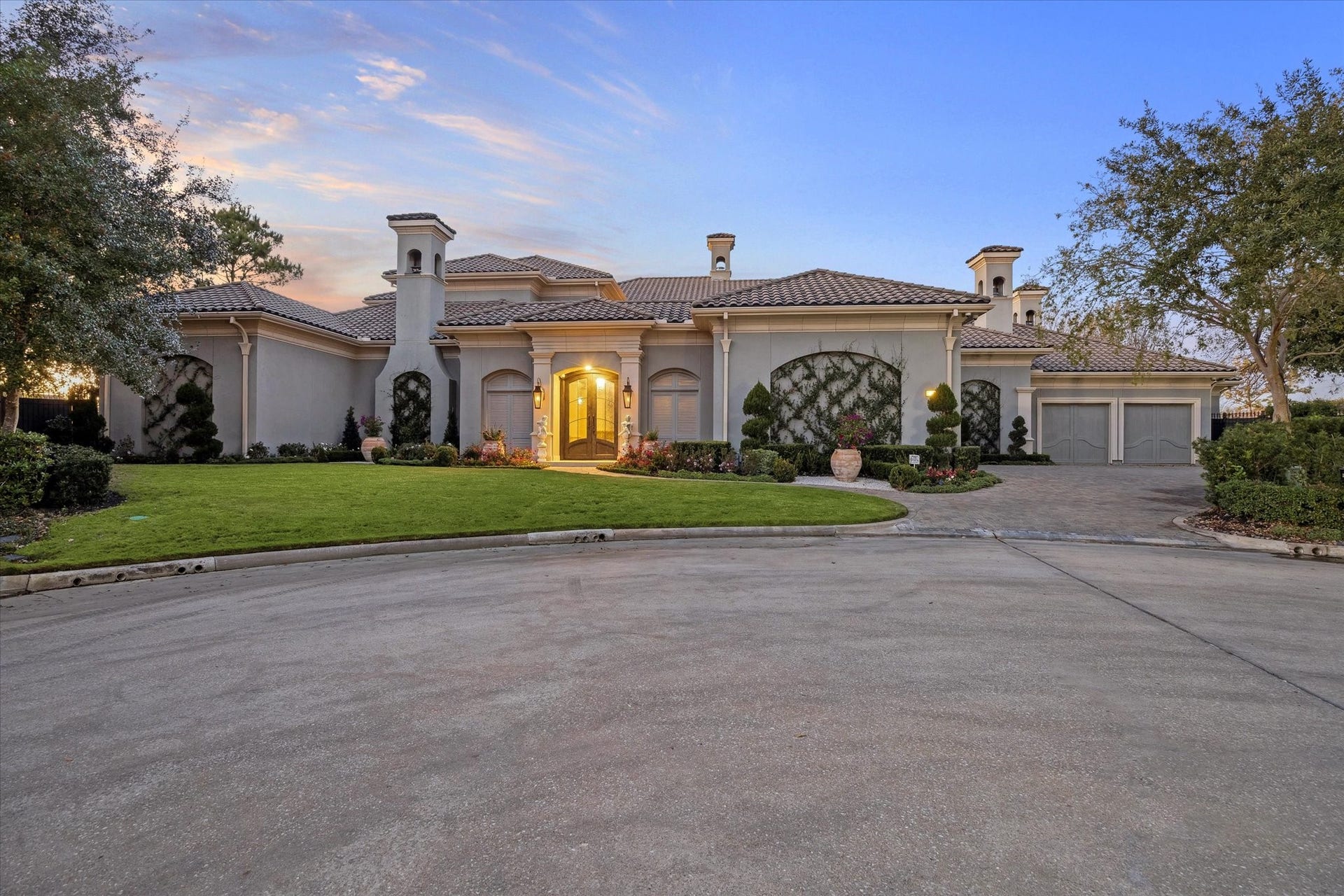 Stunning curb appeal welcomes you home with manicured landscaping, elegant architectural details, and a private cup-de-sac setting.