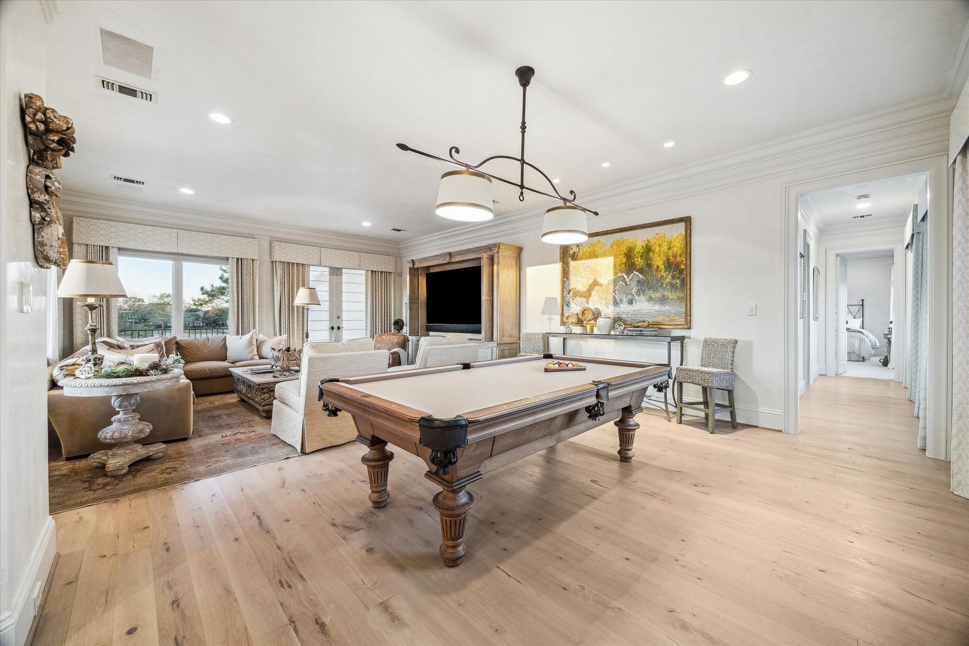 Spacious second floor living room with game room featuring a pool table, and wood flooring.