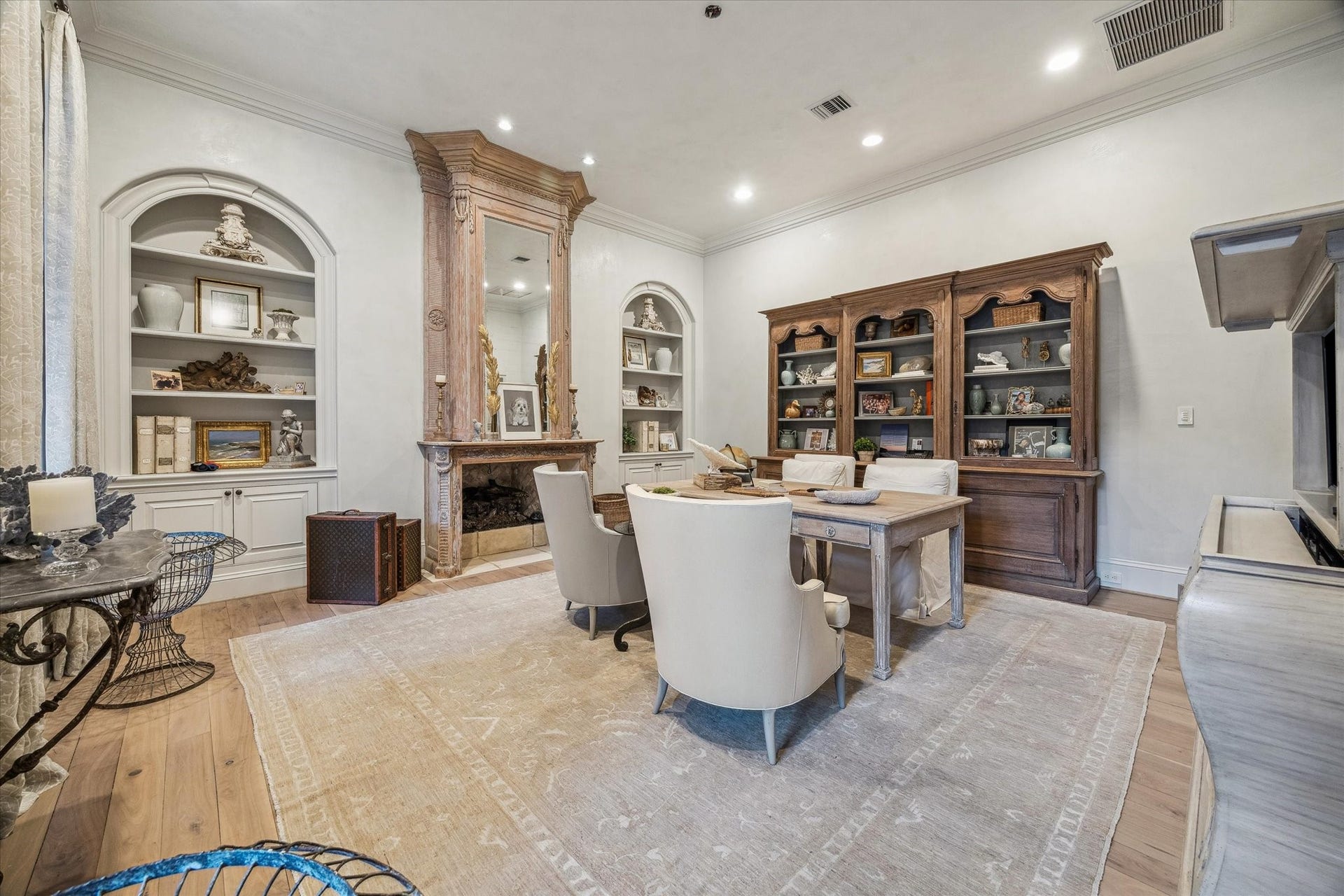 Downstairs study featuring custom built-in shelving, imported mid century fireplace surround, french oak wood flooring, and a private, flexible workspace. Overlooking the courtyard.