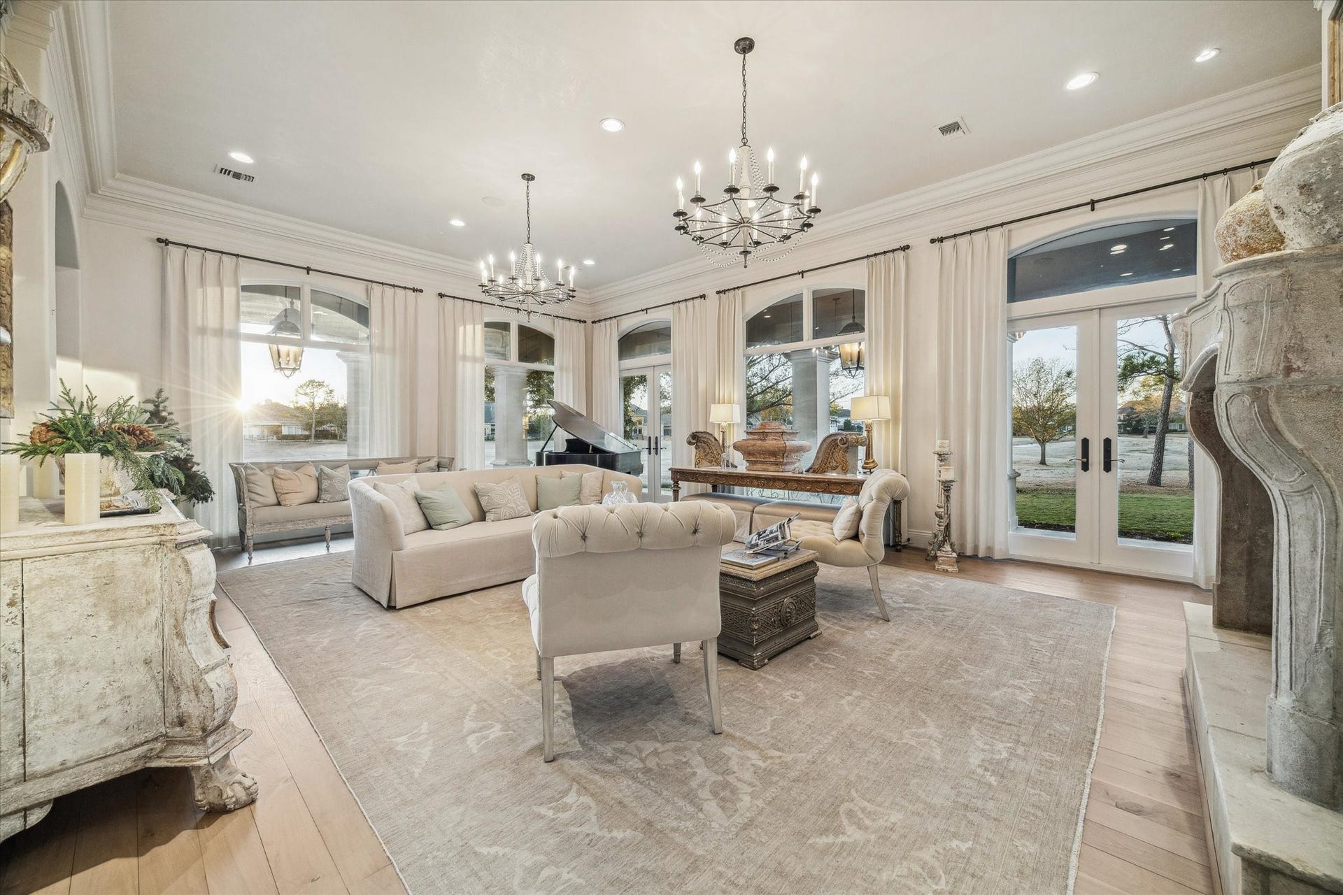 Additional view of the formal living room highlighting abundant natural light, tall windows, and seamless access to the covered outdoor space.