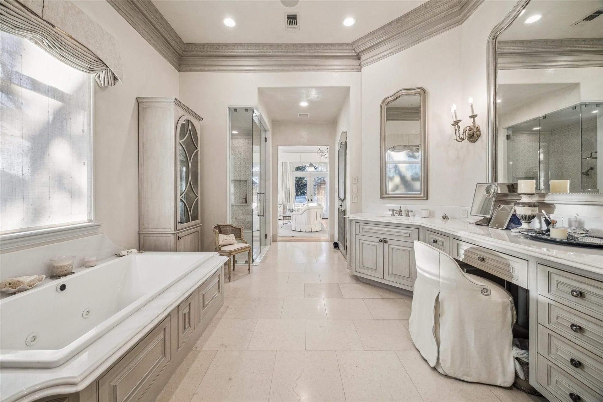 Primary bathroom featuring a soaking tub, walk-in shower, dual vanities, and elegant finishes throughout.