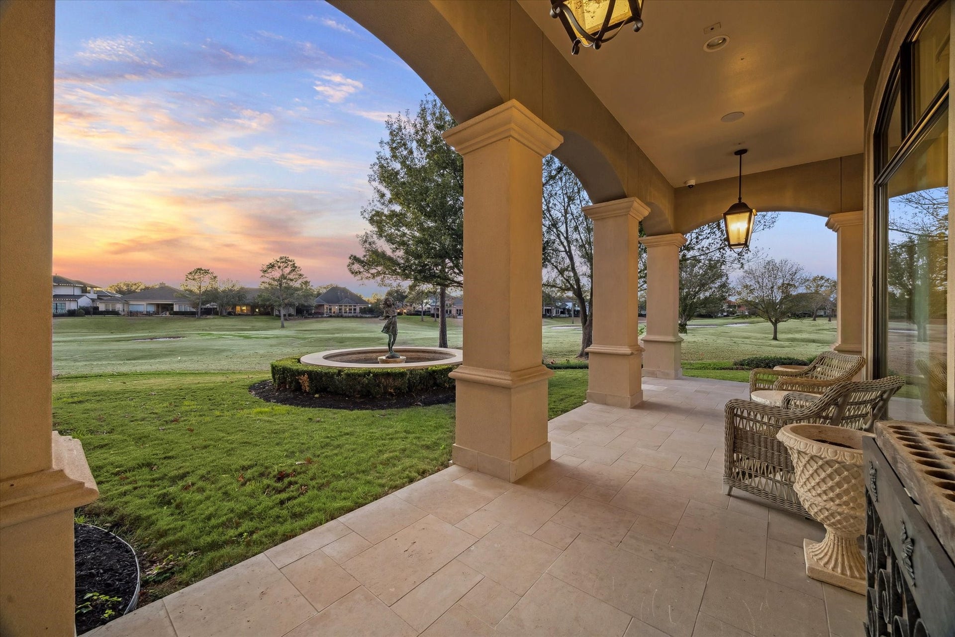 Covered patio offering peaceful views of the golf course and fountain, creating a serene outdoor retreat.