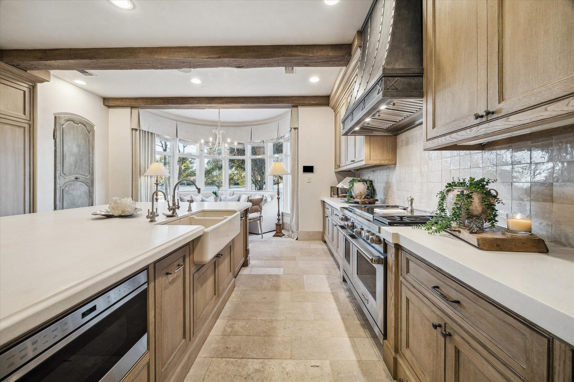 Kitchen view showcasing a farmhouse sink, expansive countertops, professional-grade range, and abundant natural light.