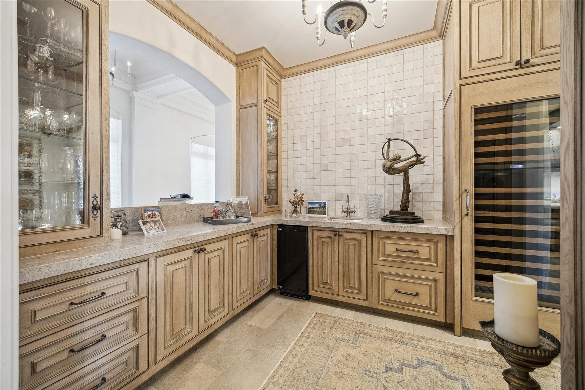 Wet bar featuring custom white oak cabinetry, 2 built-in wine storage units, sink, and ample counter space for entertaining.