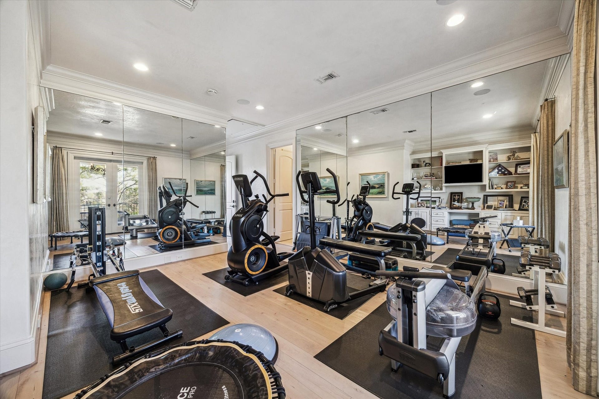 Additional bedroom currently utilized as a workout room featuring mirrored walls, wood flooring, and ample space or exercise equipment.