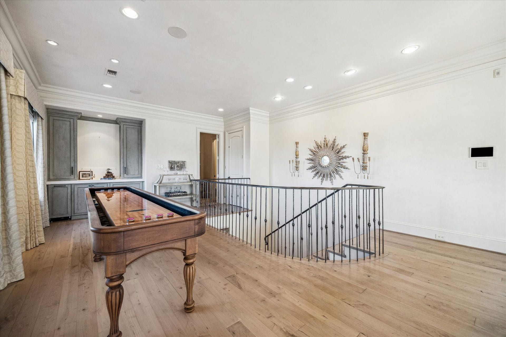 Upper-level game room featuring wood flooring and custom built-ins. Segreto plastered walls throughout.