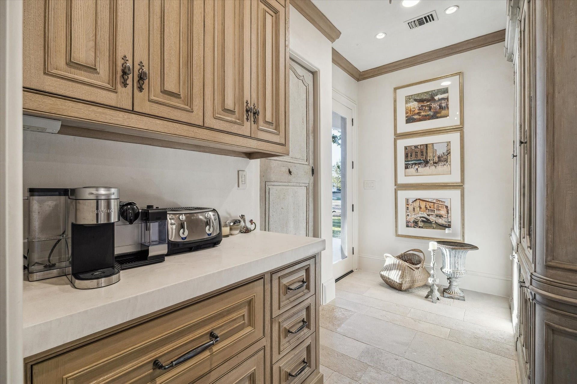 Coffee bar area featuring white oak custom cabinetry, ample counter space, and convenient access to the back patio and outdoor built in grill.