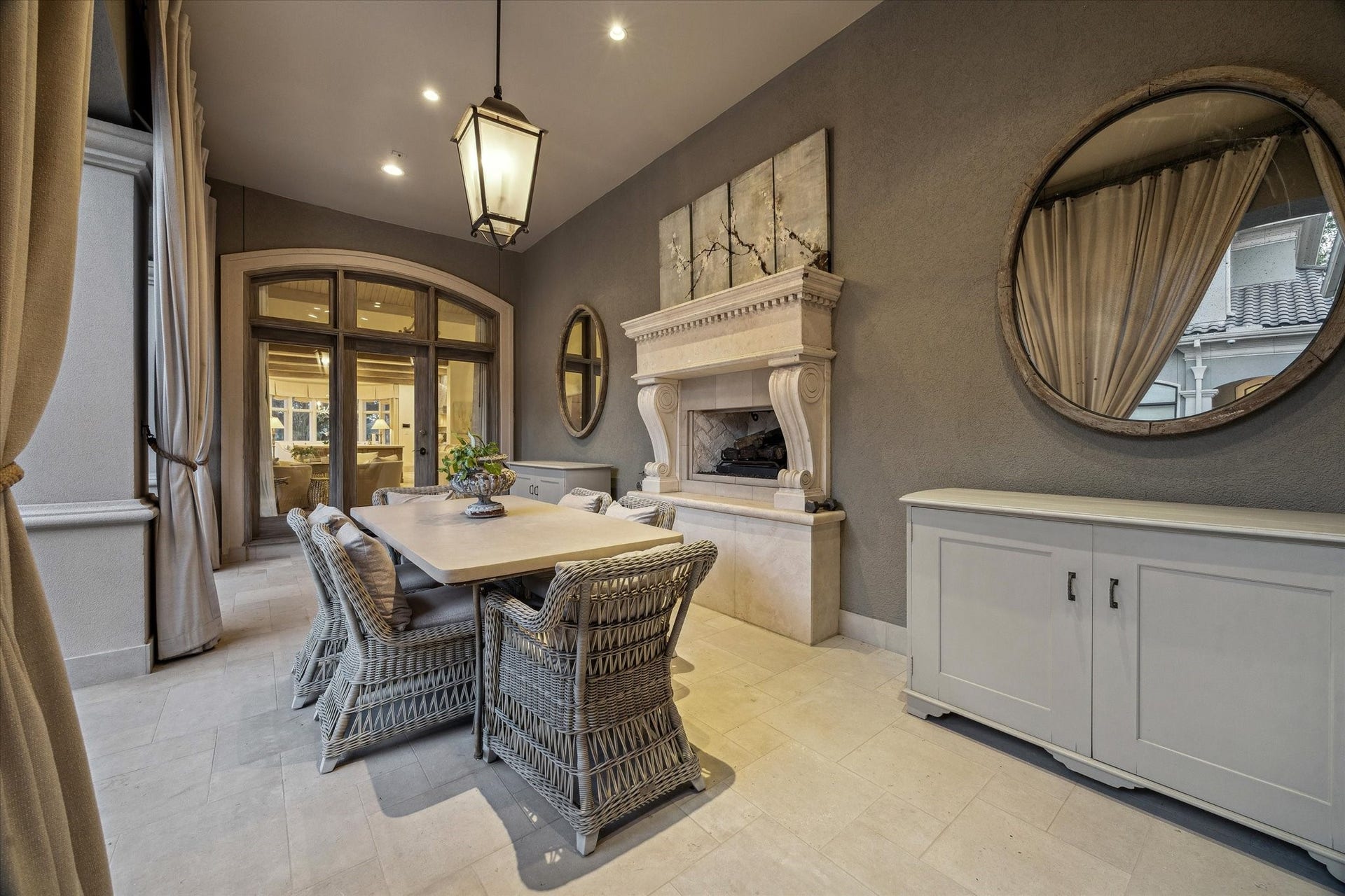 Covered outdoor dining area with beautiful stone fireplace and direct access to the courtyard and interior living spaces.