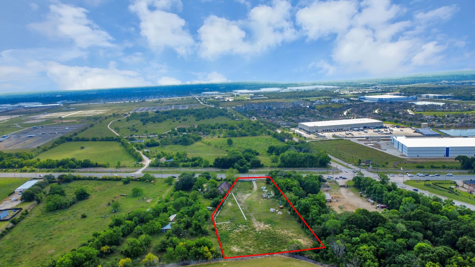 11826 Almeda Road, Houston, TX 77045 This aerial photo shows a spacious plot of land outlined in red, surrounded by greenery. It's situated near a road and close to commercial buildings, offering a blend of natural beauty and accessibility. Ideal for development or building a home with convenient access to amenities.