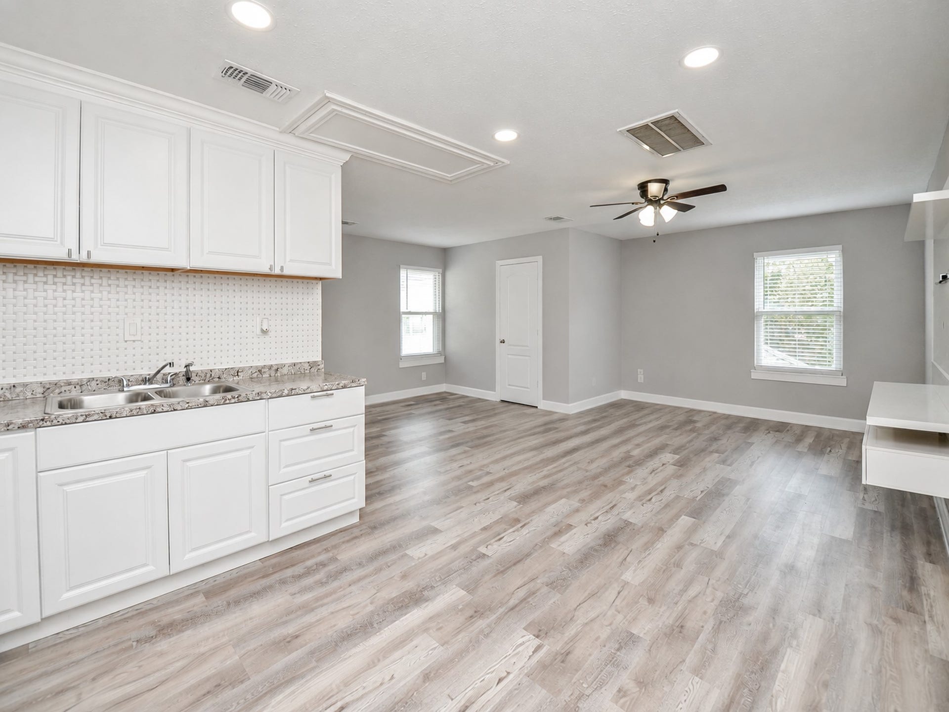 16431 Crossfield Drive, #B, Houston, TX 77095 This studio apartment is bright and spacious with an open-concept room featuring sleek laminate flooring, modern white cabinetry, and a stylish backsplash.
