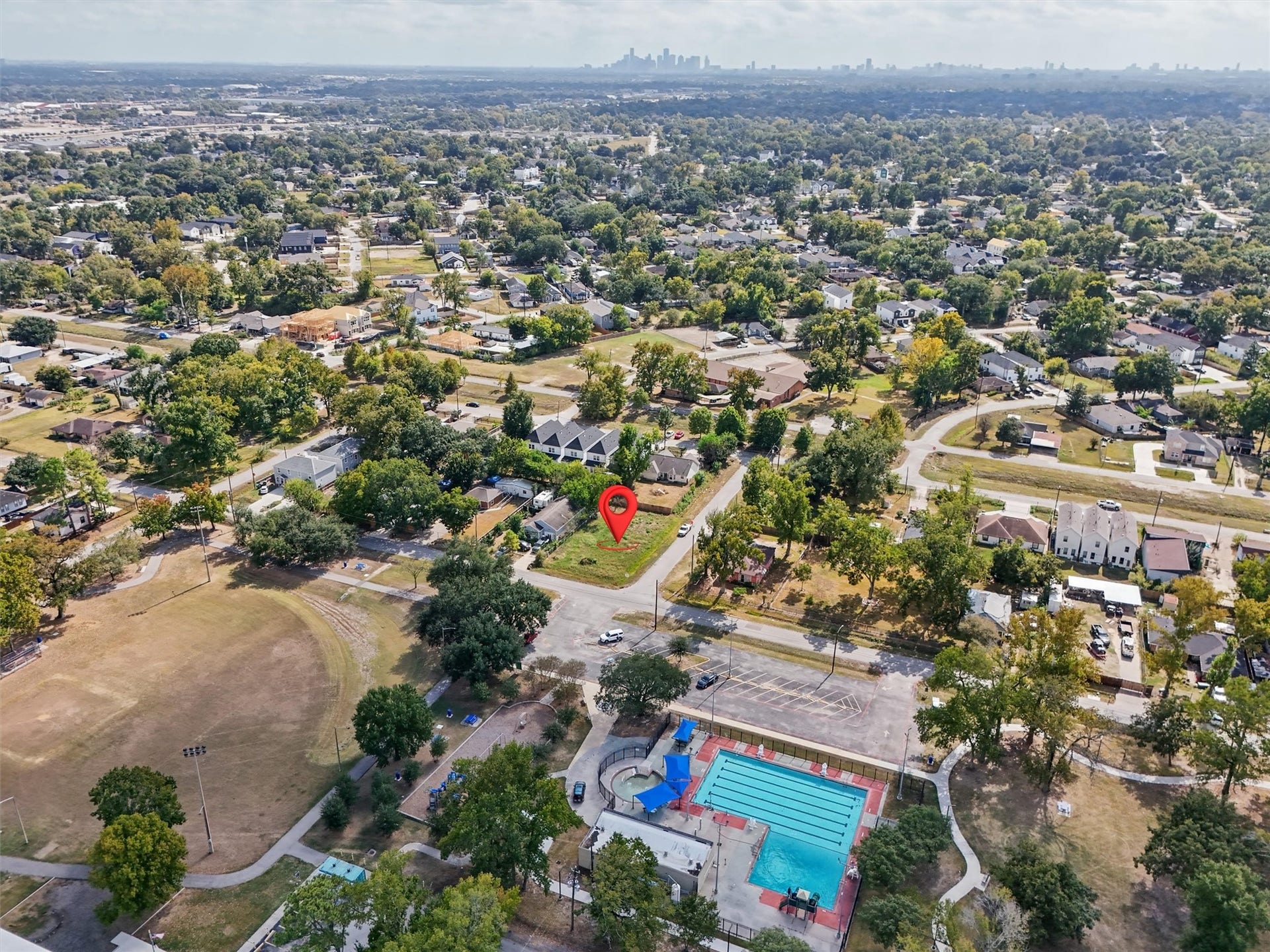 979 Conklin Street, Houston, TX 77088 The Houston skyline is visible in the distance, showcasing the property's setting within the greater Houston area. A wonderful opportunity to build your dream home with recreational amenities just across the street!