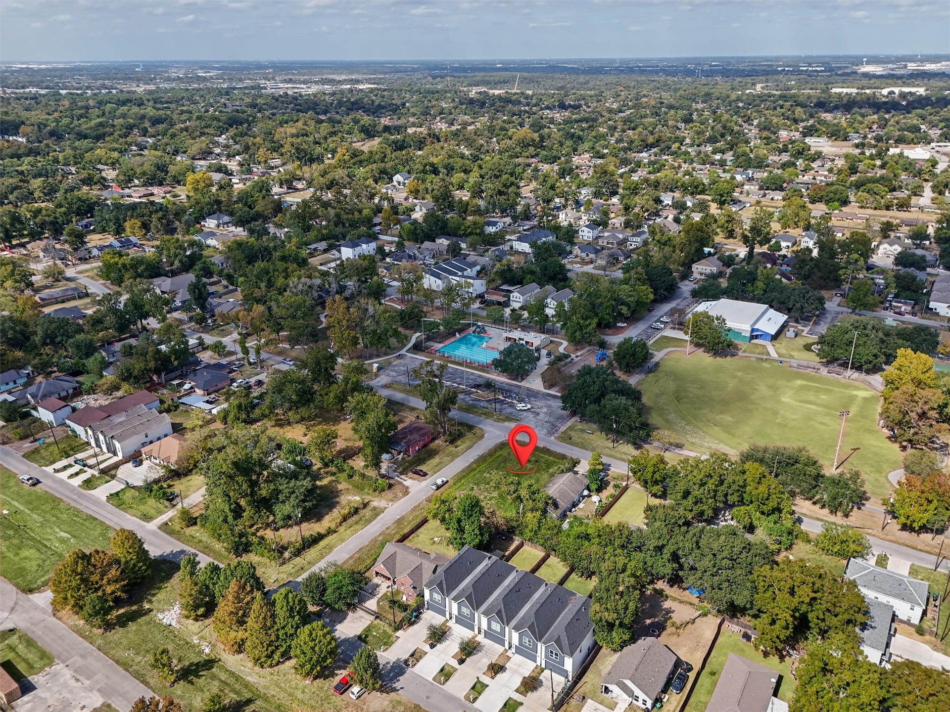 979 Conklin Street, Houston, TX 77088 This cleared corner lot, highlighted by the red marker, is ideally situated in an established neighborhood surrounded by mature trees, beautiful homes, and newer construction. Located directly across from a community swimming pool, playground, recreational fields, and green spaces, this property offers a fantastic setting to build your dream home.