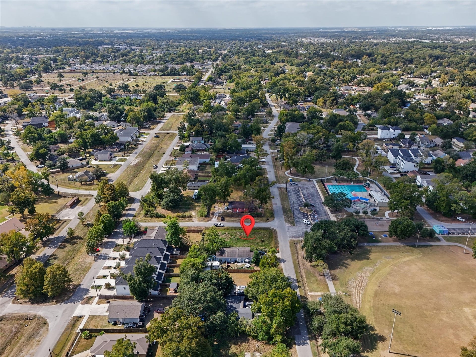 979 Conklin Street, Houston, TX 77088 Aerial view highlighting the property's location, identified by the red marker. Conveniently situated within an established neighborhood, the property offers easy access to nearby residential areas, community amenities, a swimming pool, recreational facilities, and green spaces. This bird's-eye view showcases the property's location and surrounding community.