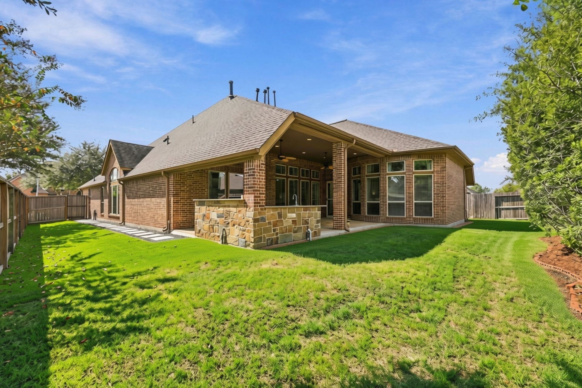 27302 Liberty Heights Lane, Fulshear, TX 77441 This view from the rear of the Backyard looks back toward the Covered Patio, showcasing the generous outdoor space and additional side yard. Convenient stepping stones provide an easy pathway from the Patio to the front yard, adding both functionality and accessibility to the outdoor areas.