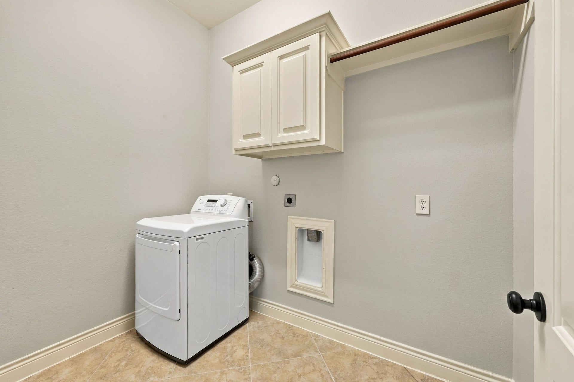 27302 Liberty Heights Lane, Fulshear, TX 77441 The spacious Laundry Room offers excellent functionality with built-in cabinetry, a hanging bar for air-drying clothes, and an additional storage shelf. There is also plenty of room to accommodate an extra refrigerator, providing added convenience and storage options for a busy household.