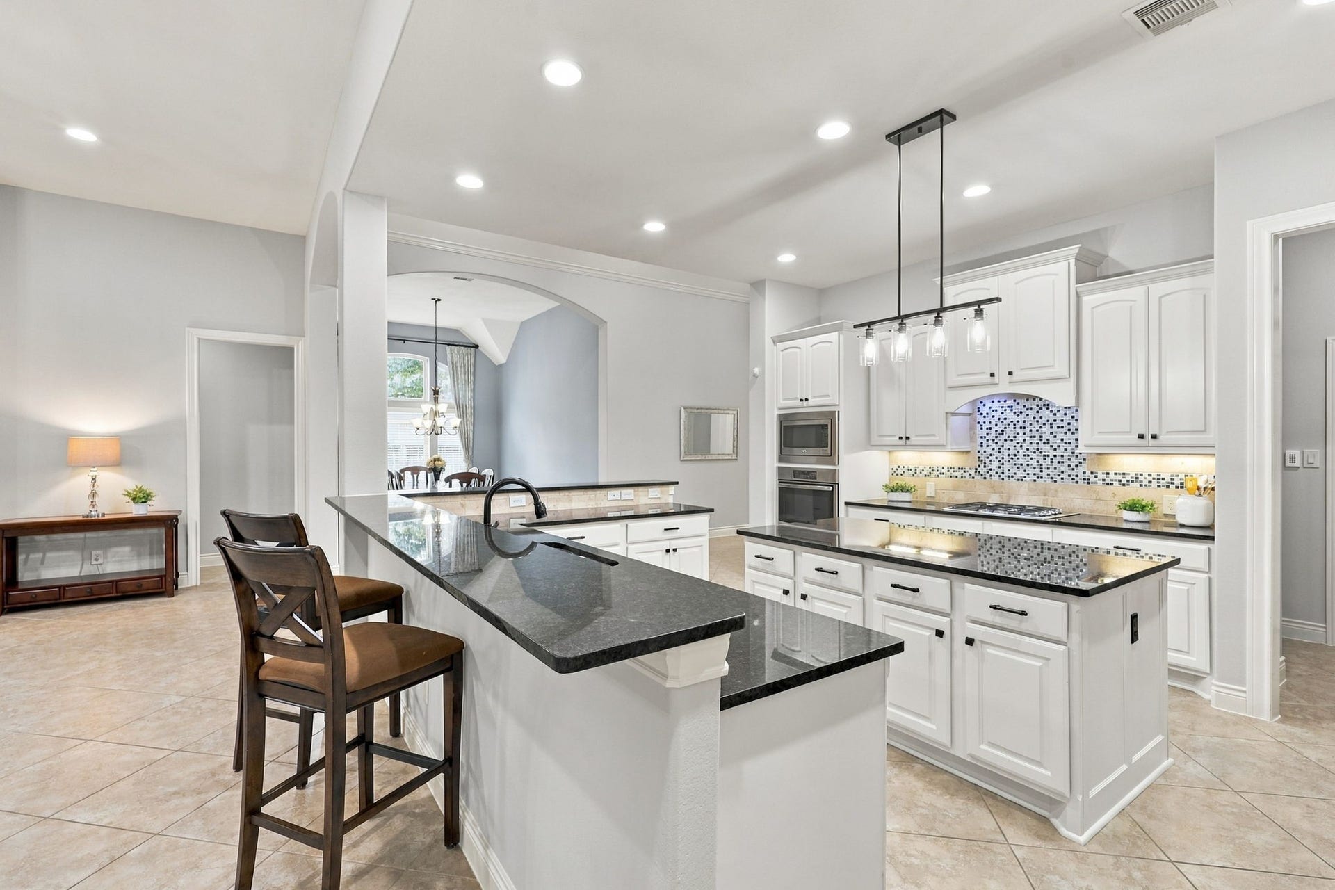 27302 Liberty Heights Lane, Fulshear, TX 77441 This view offers a closer look at the Breakfast Bar and highlights the additional seating options this thoughtfully designed floor plan provides, creating a welcoming space for casual dining and gathering with family and friends.