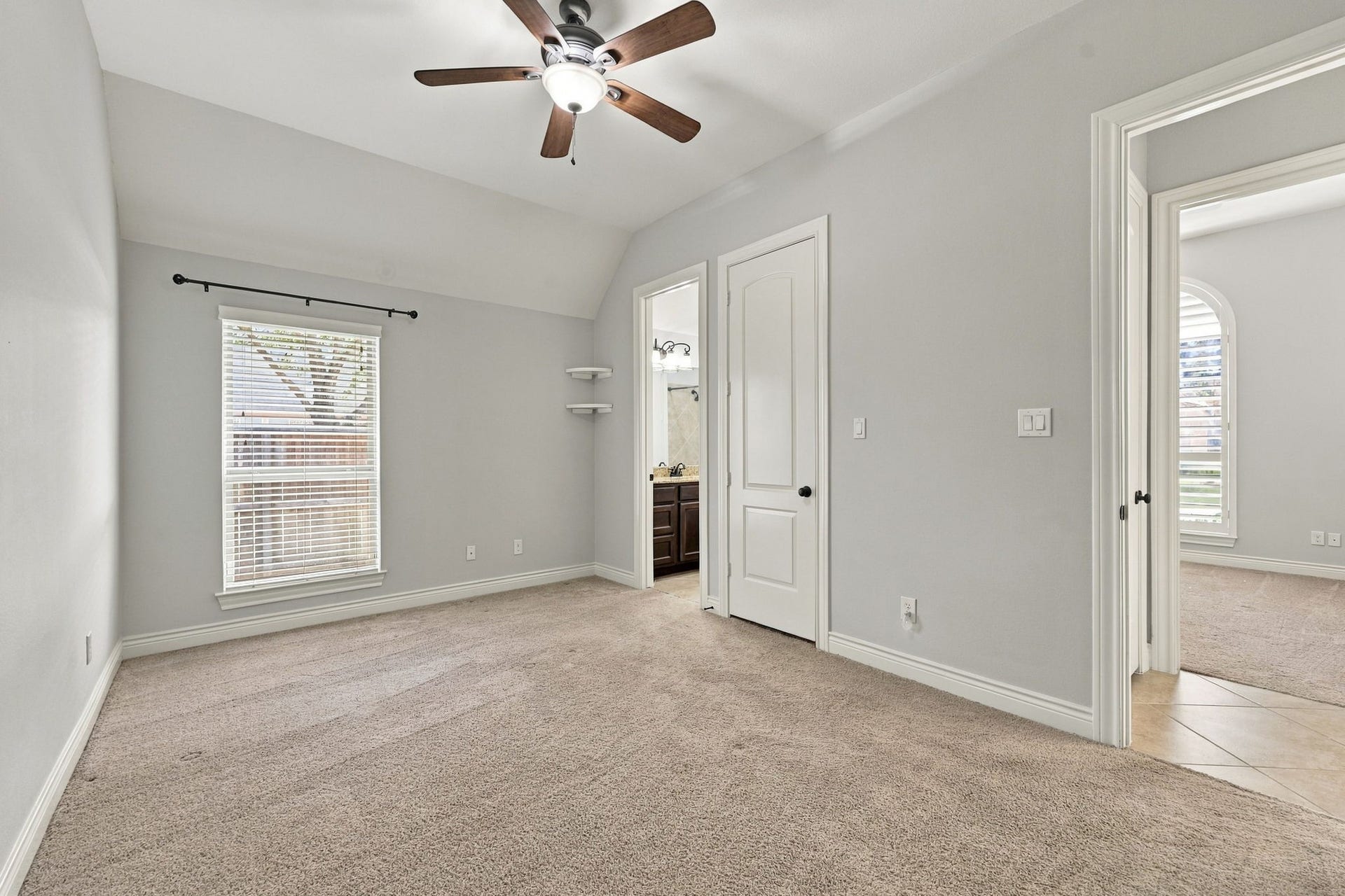 27302 Liberty Heights Lane, Fulshear, TX 77441 Bedroom #3 features a large window with 2-inch blinds, allowing natural light to fill the space while providing privacy. This generously sized Bedroom also offers a walk-in closet and direct access to the Full Bathroom shown in the previous photo, providing added convenience and functionality.
