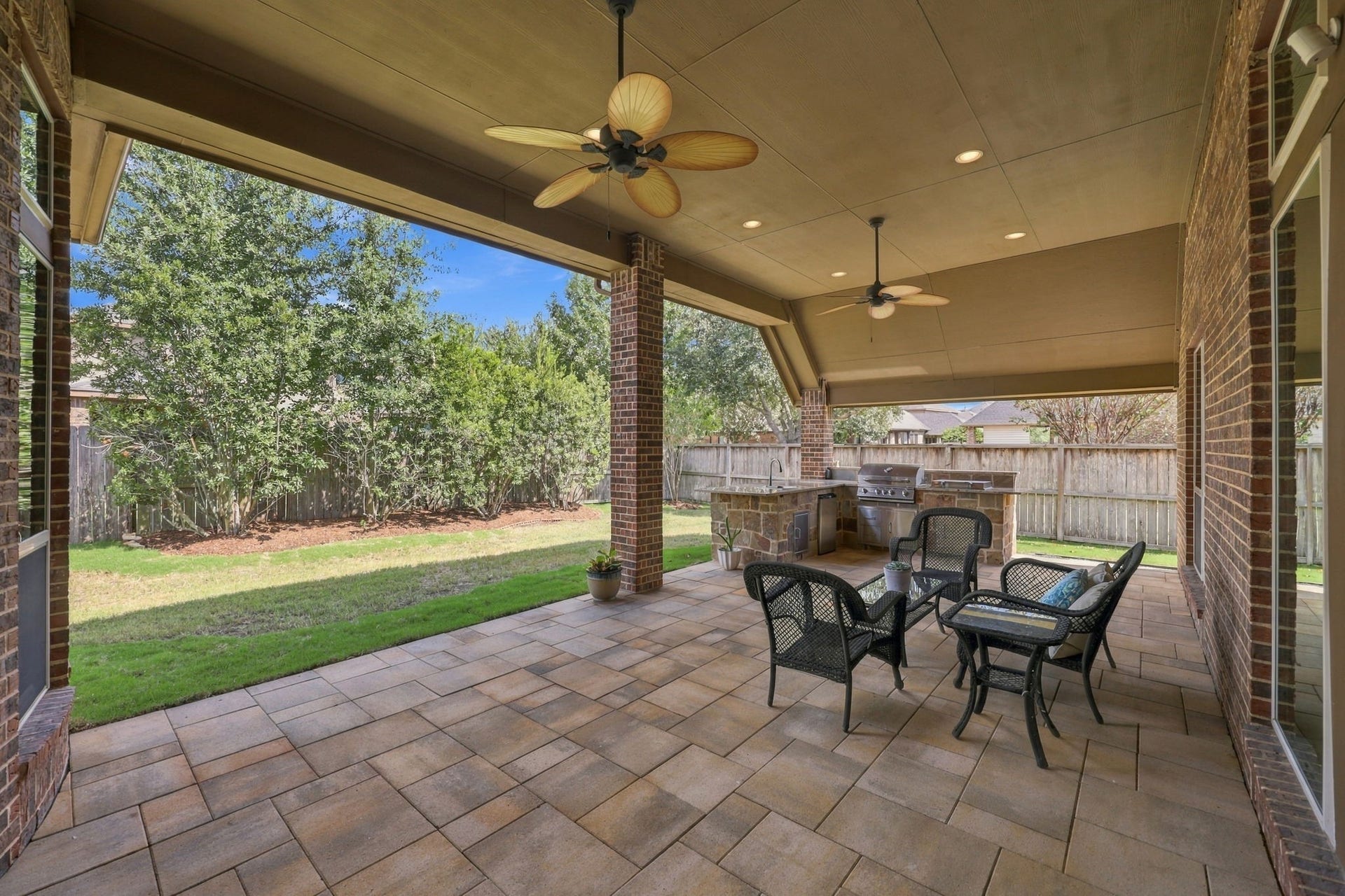 27302 Liberty Heights Lane, Fulshear, TX 77441 Let's step outside to the gorgeous Covered Back Patio, featuring beautiful flagstone flooring and a built-in Summer Kitchen. This inviting outdoor living space is perfect for grilling, entertaining guests, or simply relaxing and enjoying the privacy of your backyard.