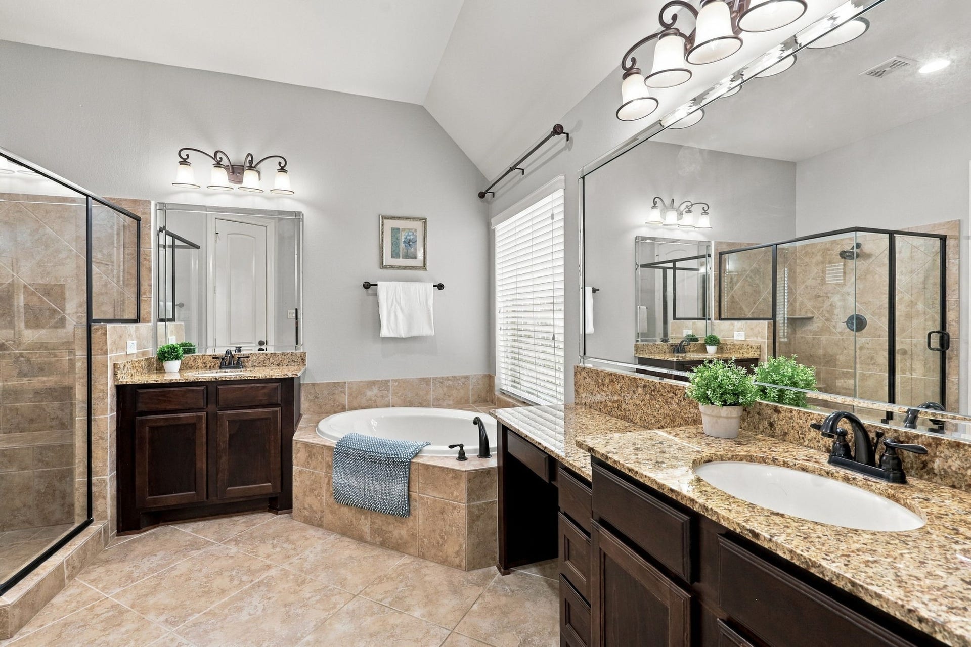 27302 Liberty Heights Lane, Fulshear, TX 77441 The spacious Primary Bathroom features dual vanities with granite countertops, undermount sinks, and oil-rubbed bronze fixtures and faucets. A corner soaking tub adds a relaxing touch, creating the perfect spot to unwind at the end of the day.
