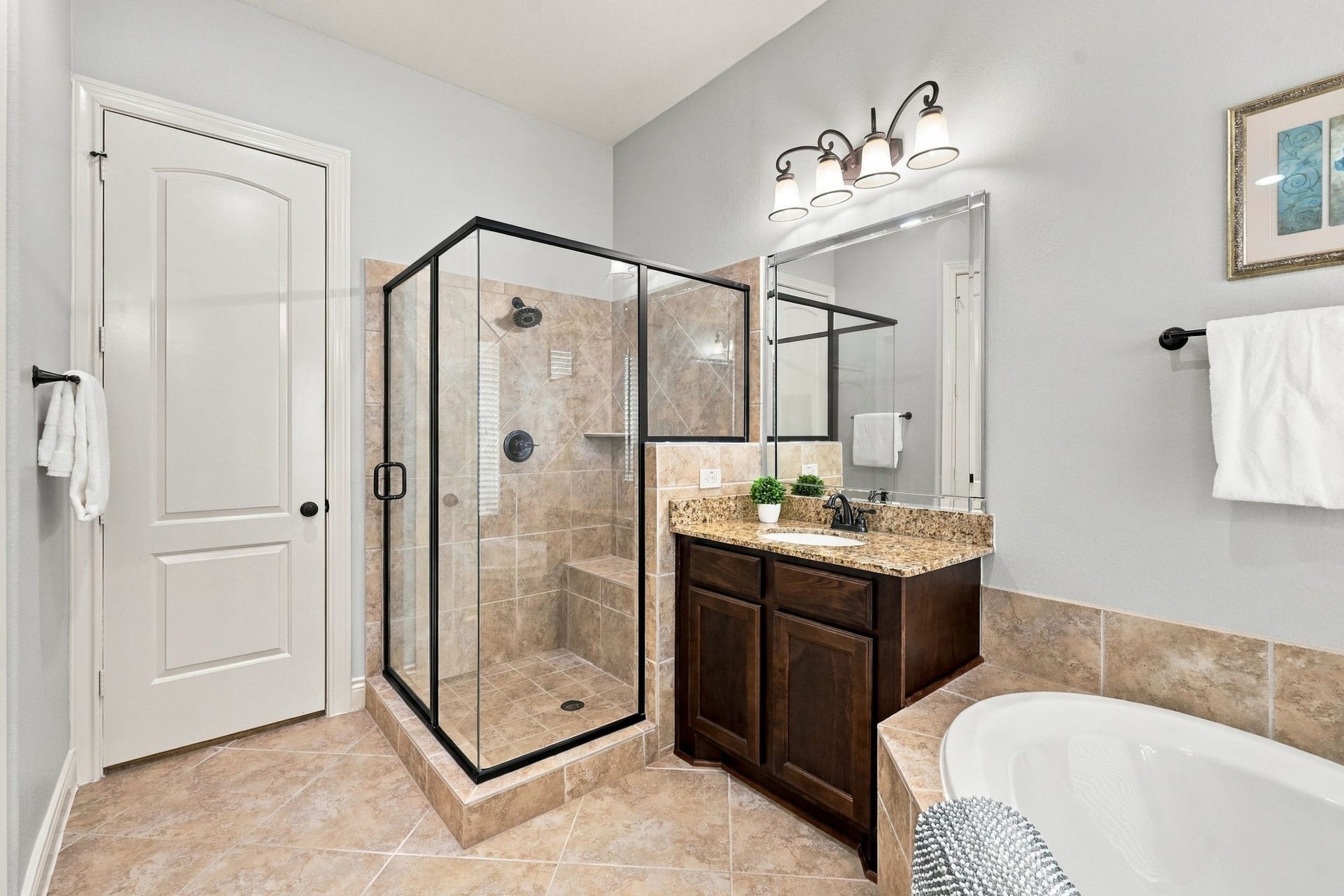 27302 Liberty Heights Lane, Fulshear, TX 77441 This view of the Primary Bathroom highlights the second vanity, spacious walk-in shower, and the entrance to one of two walk-in closets, offering ample storage and added convenience within the private Primary Suite.