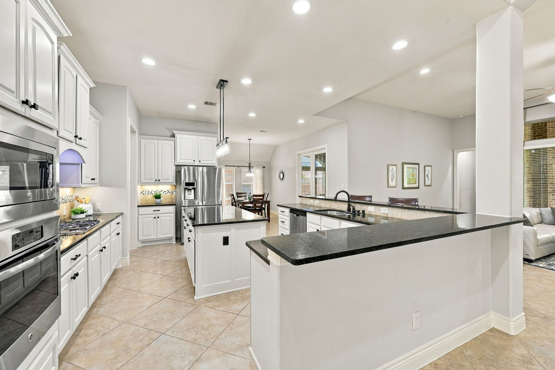 27302 Liberty Heights Lane, Fulshear, TX 77441 This view further highlights the generous size of the Kitchen, offering plenty of room to cook, gather, and entertain. The L-shaped Breakfast Bar provides additional seating for six to seven people, making it an ideal spot for casual meals, morning coffee, or visiting with family and friends while preparing meals.
