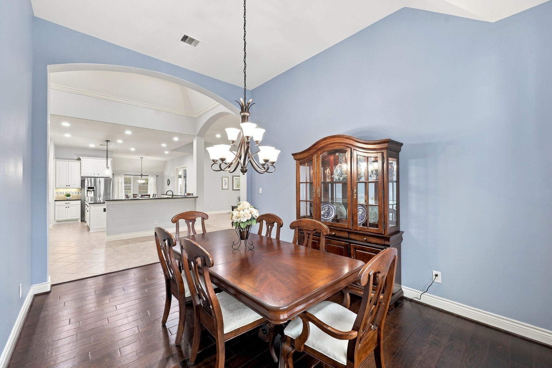 27302 Liberty Heights Lane, Fulshear, TX 77441 The spacious Formal Dining Room also features gorgeous wood flooring and a stunning nine-globe wrought-iron chandelier that adds elegance and character. Conveniently located directly across from the Kitchen, this room is ideal for entertaining and everyday gatherings.