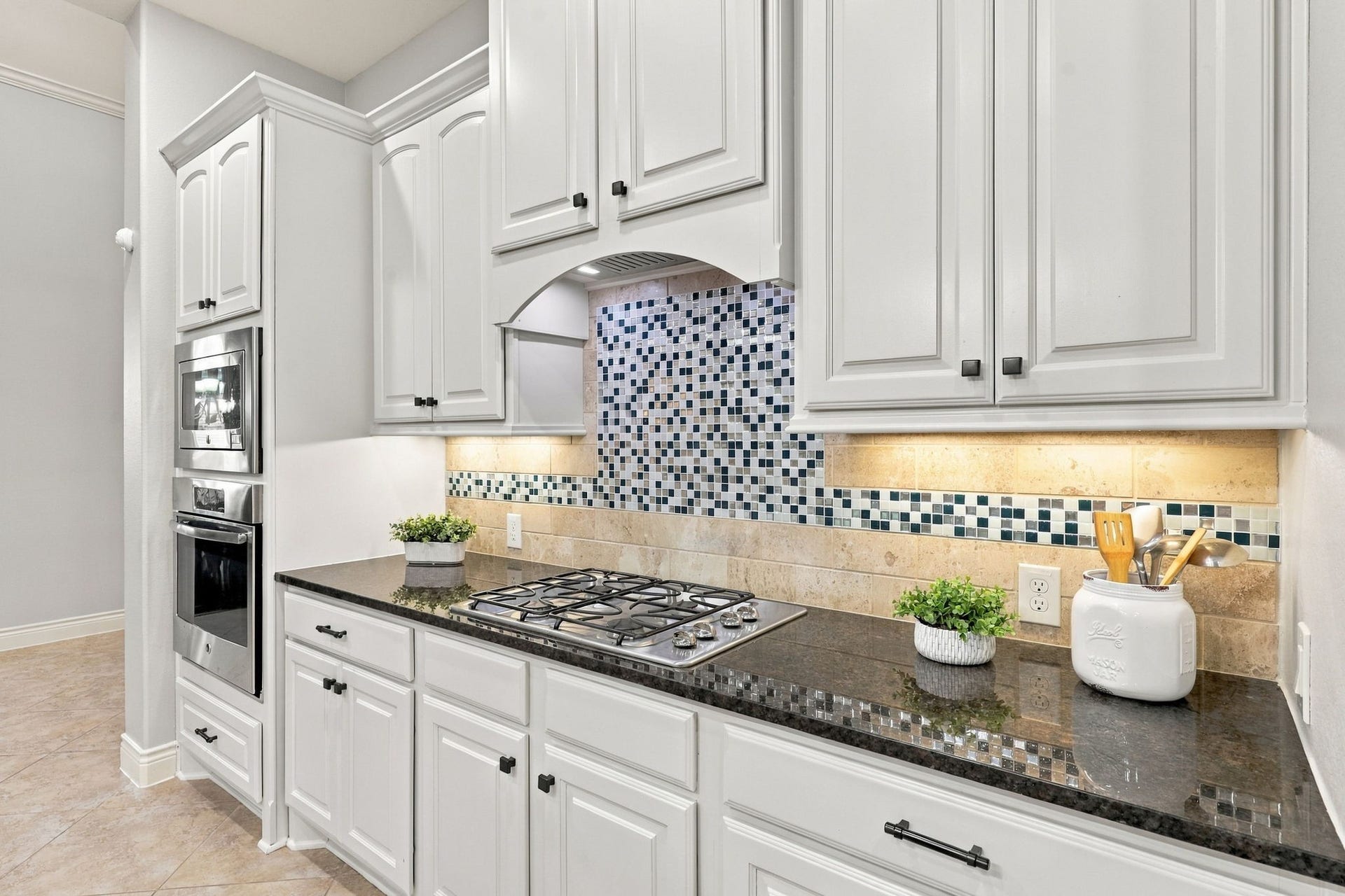 27302 Liberty Heights Lane, Fulshear, TX 77441 The Kitchen is equipped with GE stainless steel appliances, including a 4-burner gas cooktop, microwave, dishwasher and electric oven, offering a functional setup for everyday cooking and entertaining.