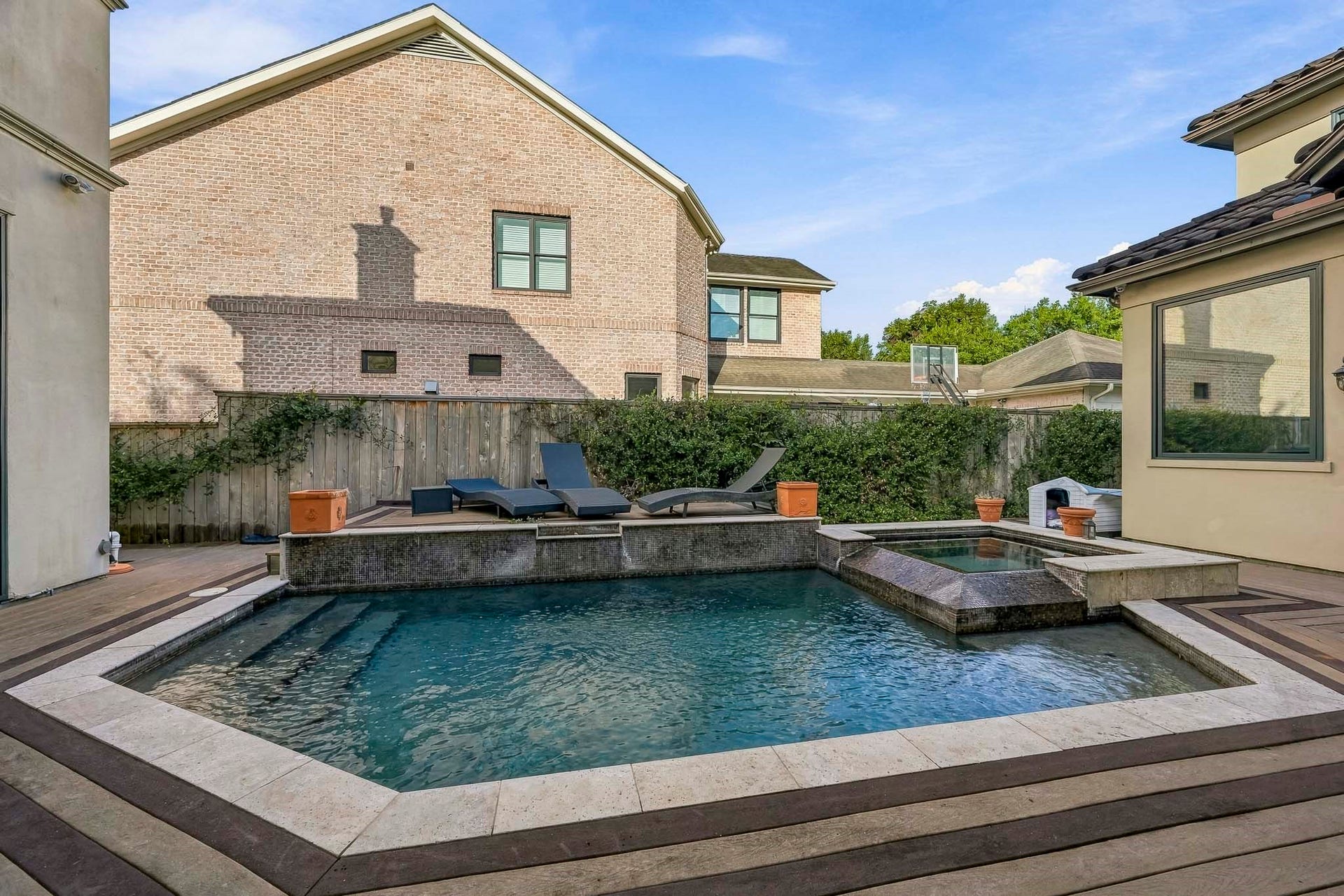 Experience luxury outdoor living with this stylish pool area, featuring a modern design, relaxing sun loungers, and a serene water feature, perfect for entertaining or unwinding.