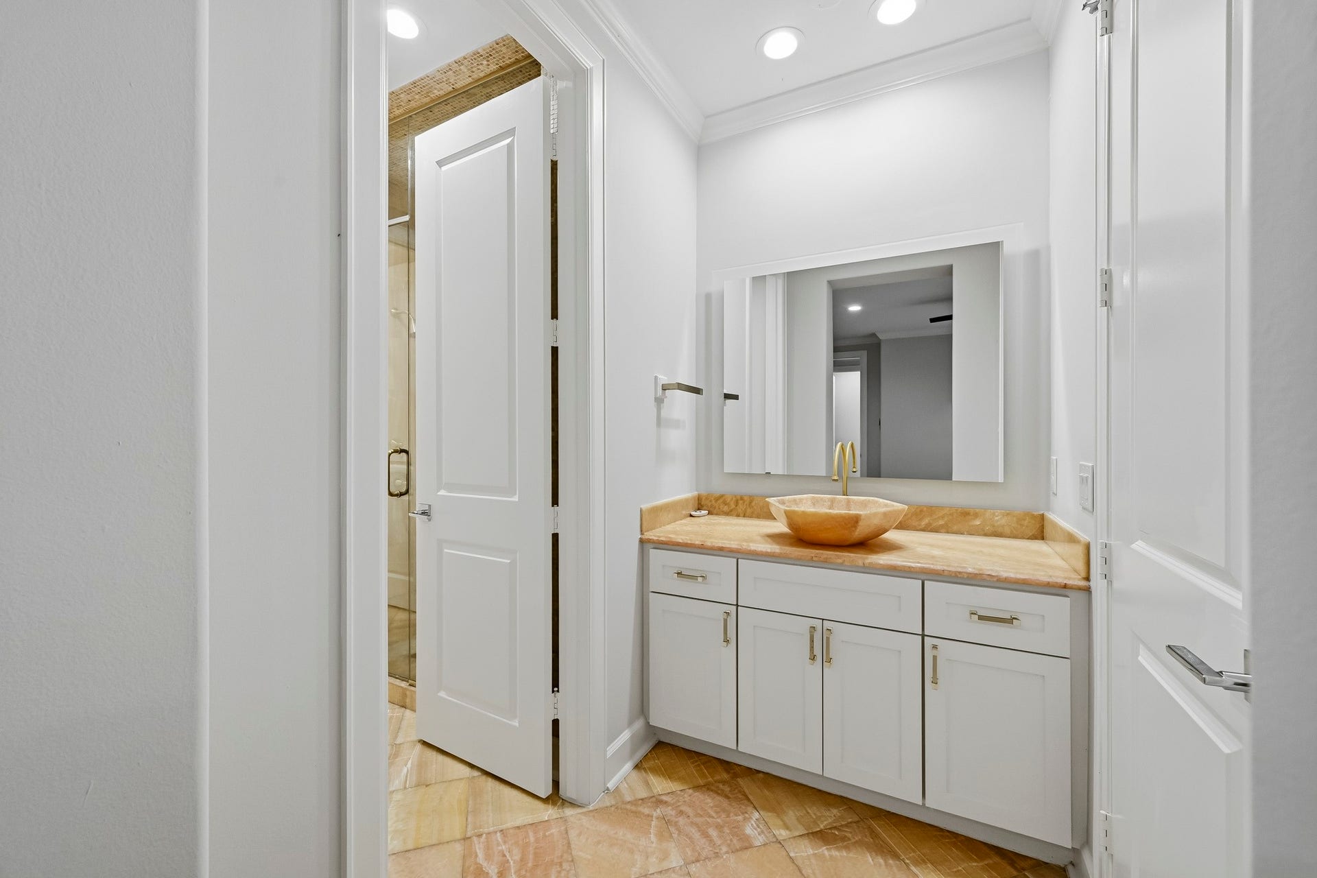 Elegant jack and jill bathroom featuring a stylish vessel sink atop a sleek vanity, complemented by modern fixtures and ample lighting.