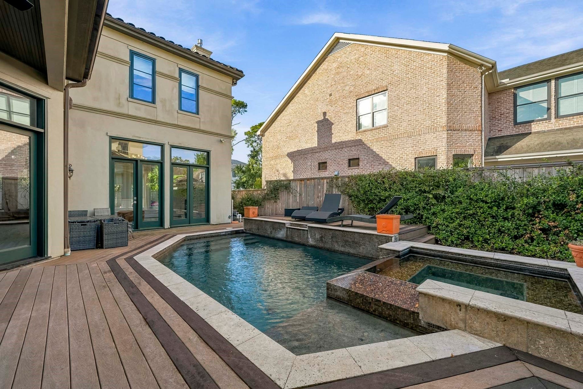 Experience luxury living with a stunning backyard featuring a sleek pool and spa, surrounded by elegant decking and lush greenery, perfect for relaxation and entertainment.