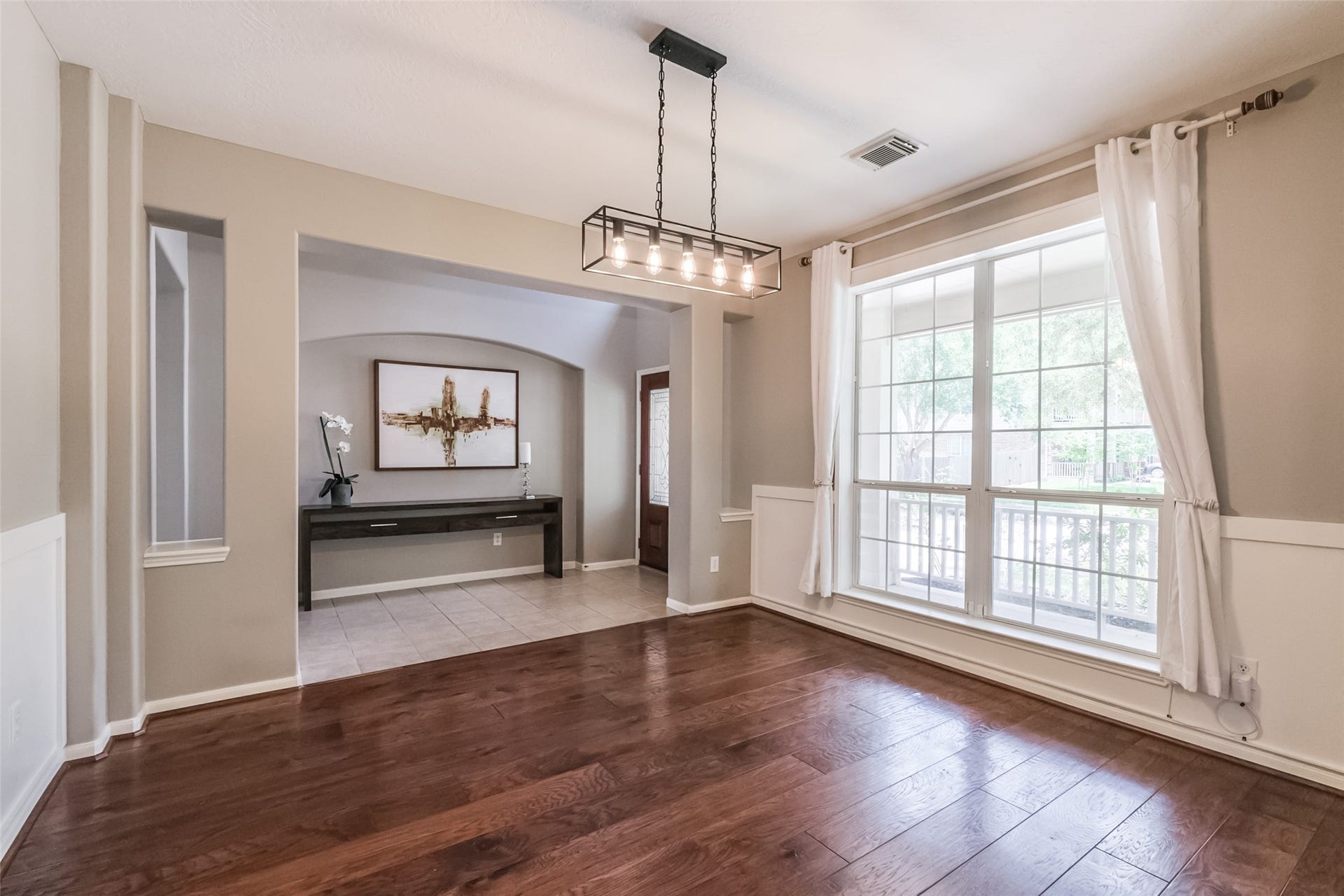 10314 Five Oaks Crossing, Missouri City, TX 77459 Bright dining area with hardwood floors, large window, stylish light fixture.