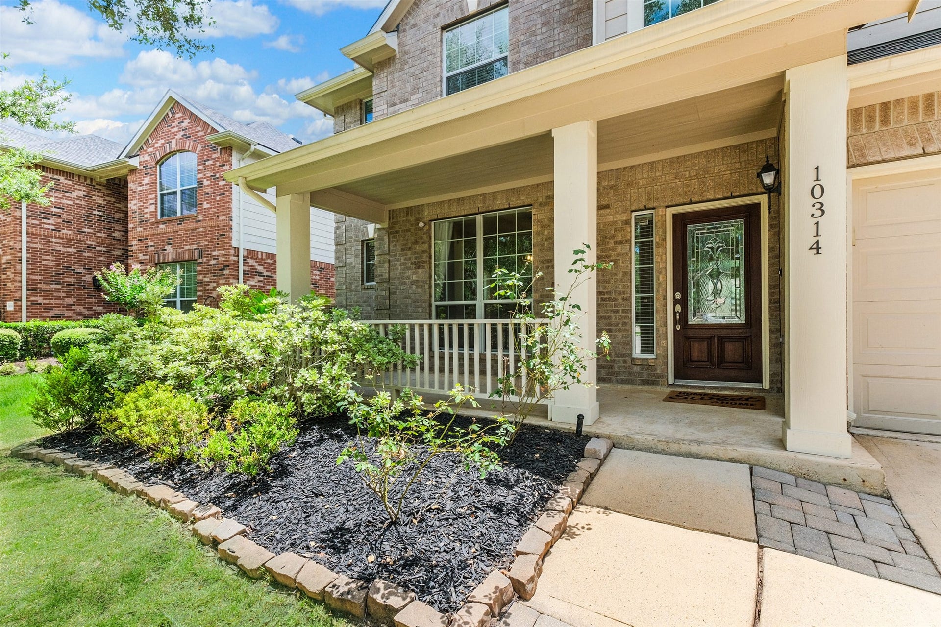 10314 Five Oaks Crossing, Missouri City, TX 77459 Charming front porch with brick exterior, manicured landscaping, and a welcoming entryway. Perfect for relaxing and enjoying the neighborhood view.