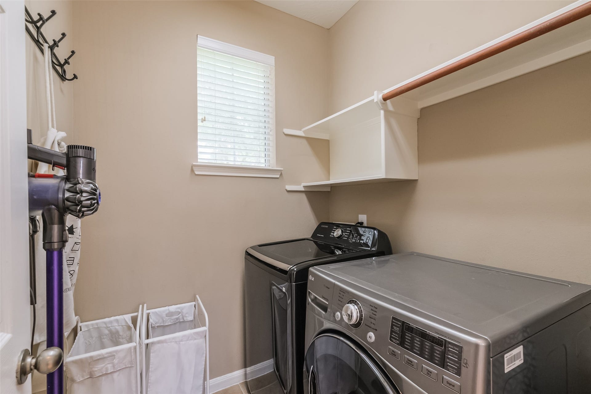 10314 Five Oaks Crossing, Missouri City, TX 77459 Well-organized laundry room with neutral walls, featuring a window for natural light.