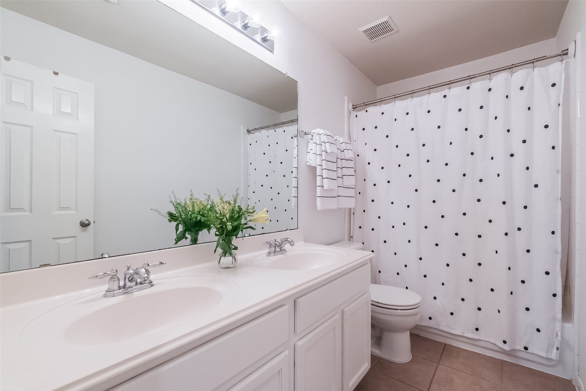 10314 Five Oaks Crossing, Missouri City, TX 77459 Bright and clean bathroom featuring a double sink vanity, white cabinetry, tub/shower combination.