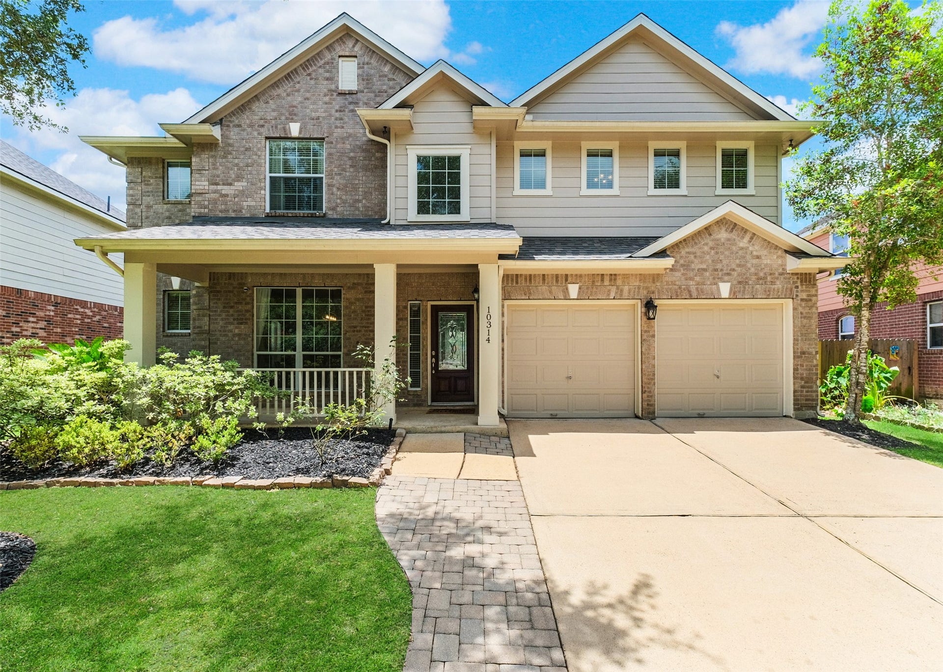 10314 Five Oaks Crossing, Missouri City, TX 77459 This inviting two-story home features a charming brick and siding exterior, a welcoming covered porch, and a spacious two-car garage. Lush landscaping enhances its curb appeal, making it an ideal choice for a family.