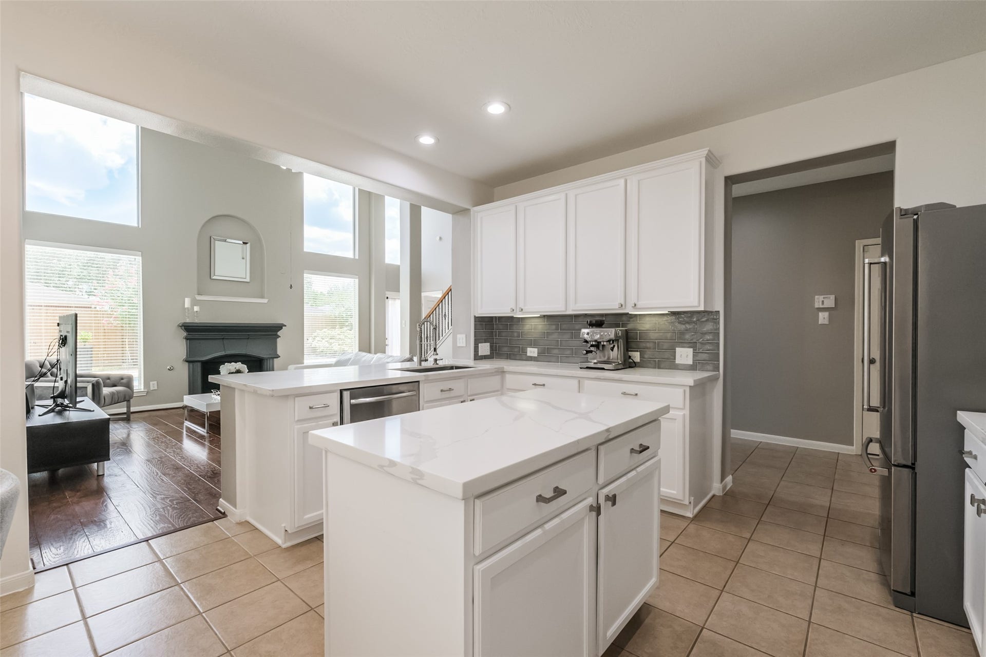 10314 Five Oaks Crossing, Missouri City, TX 77459 Bright, open-concept kitchen with modern white cabinetry & sleek countertops.