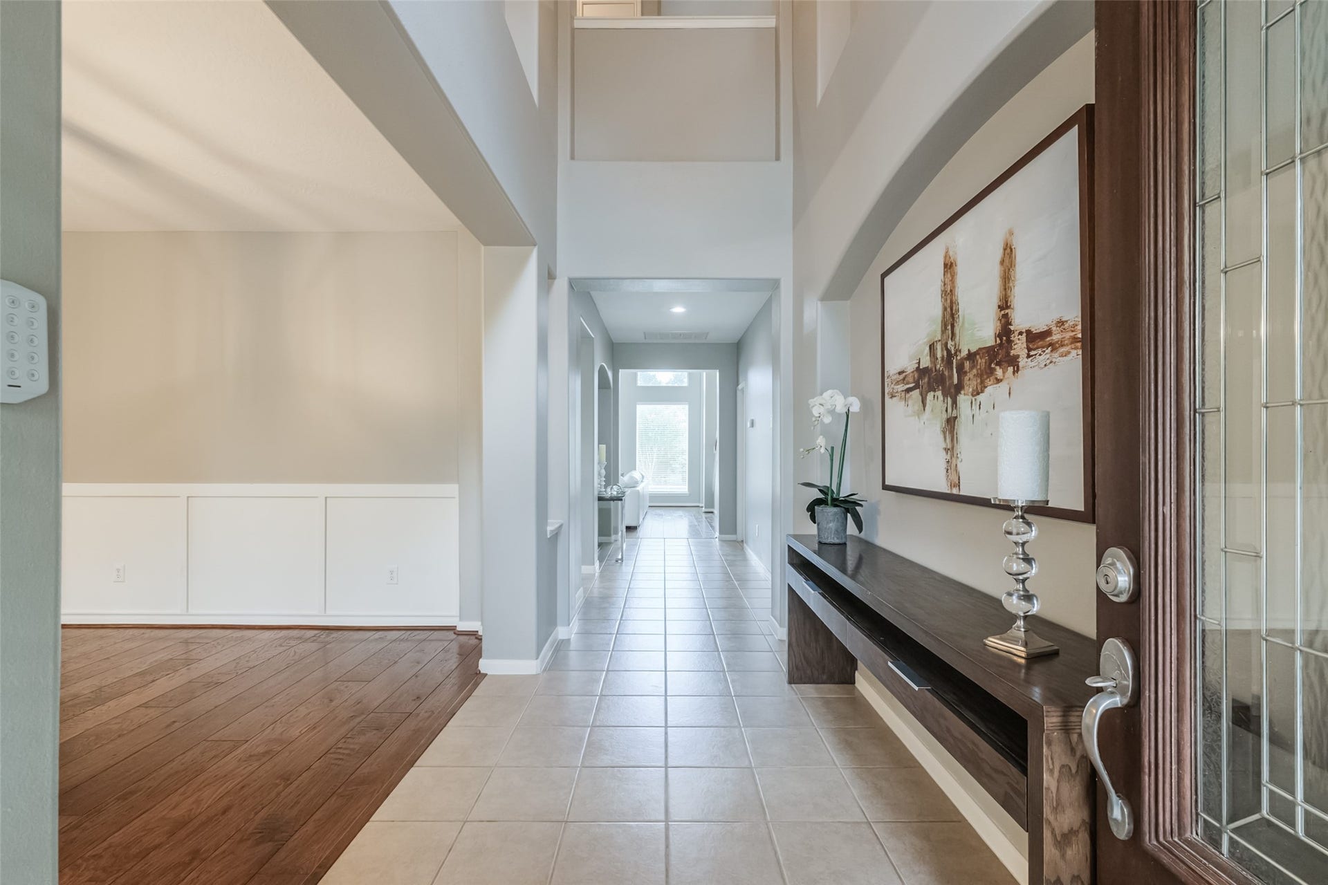 10314 Five Oaks Crossing, Missouri City, TX 77459 This inviting entryway features high ceilings, a mix of tile and wood flooring, and a long hallway leading to a bright, open space.