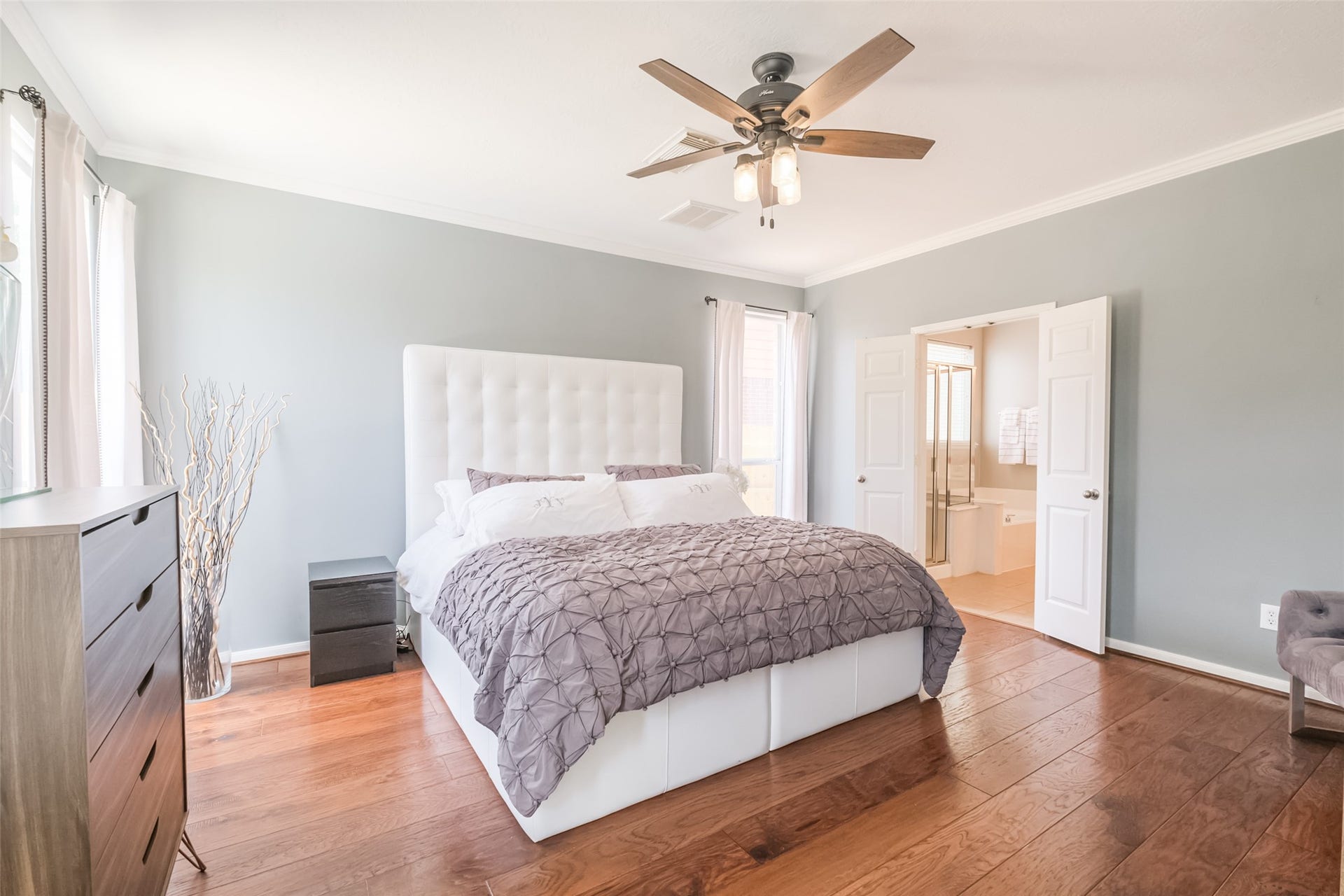 10314 Five Oaks Crossing, Missouri City, TX 77459 Bright and spacious primary bedroom with hardwood floors and neutral walls.
